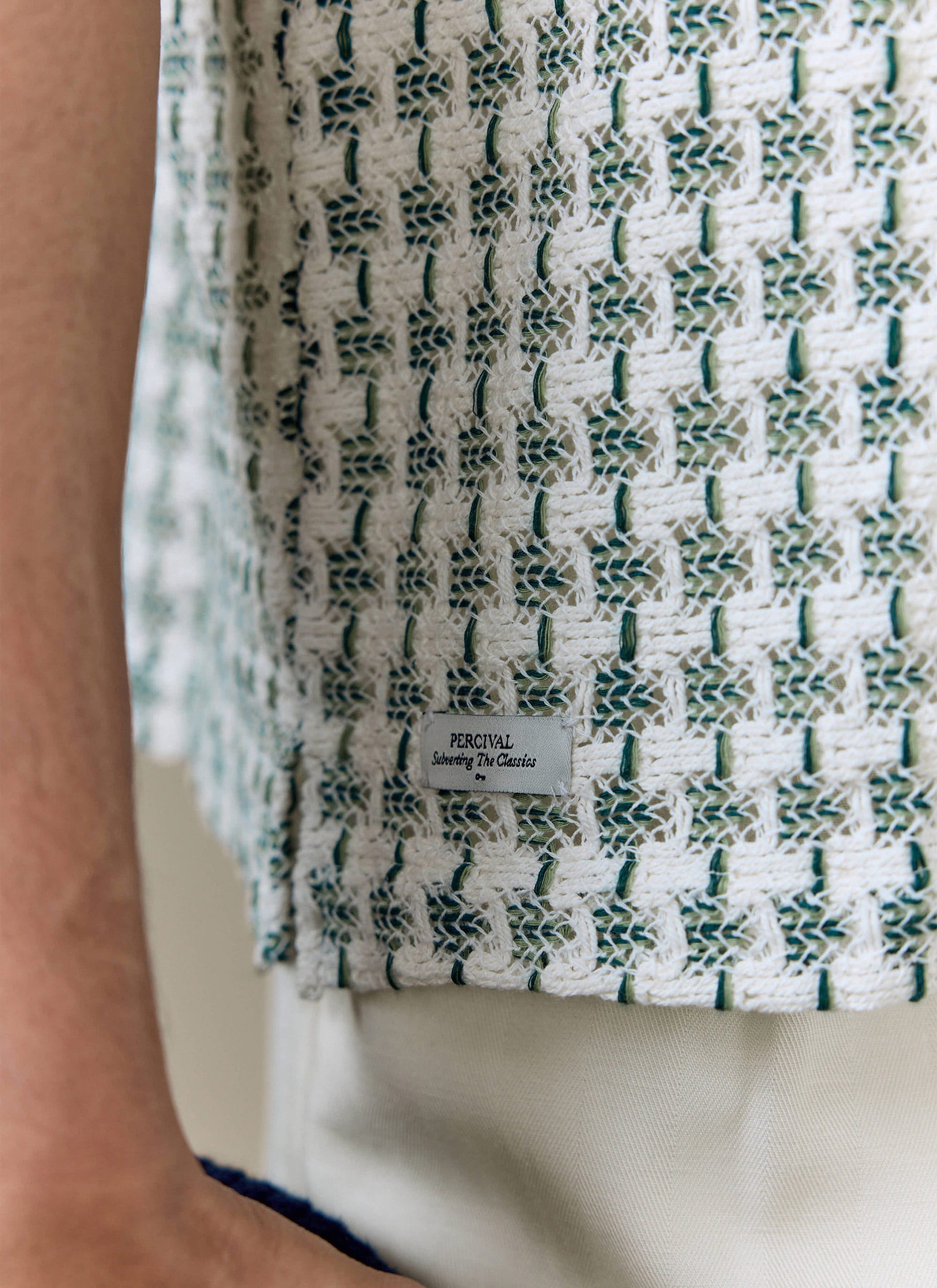 Close-up of the Percival Freddie Crochet Boxy Shirt in green, showing the textured cotton weave and branded side tag.