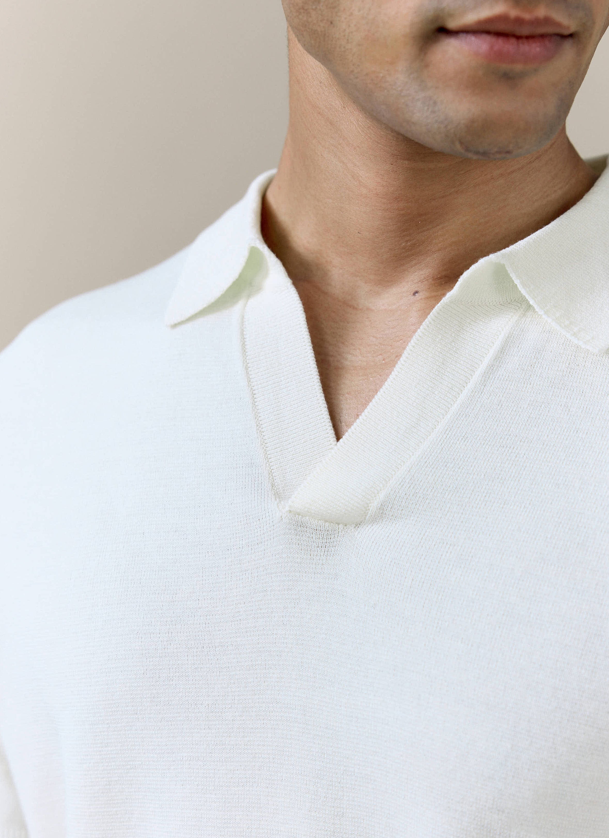 Close-up of the open Johnny collar on the cream Laurence knitted polo by Percival, showing the fine linen-lyocell knit.