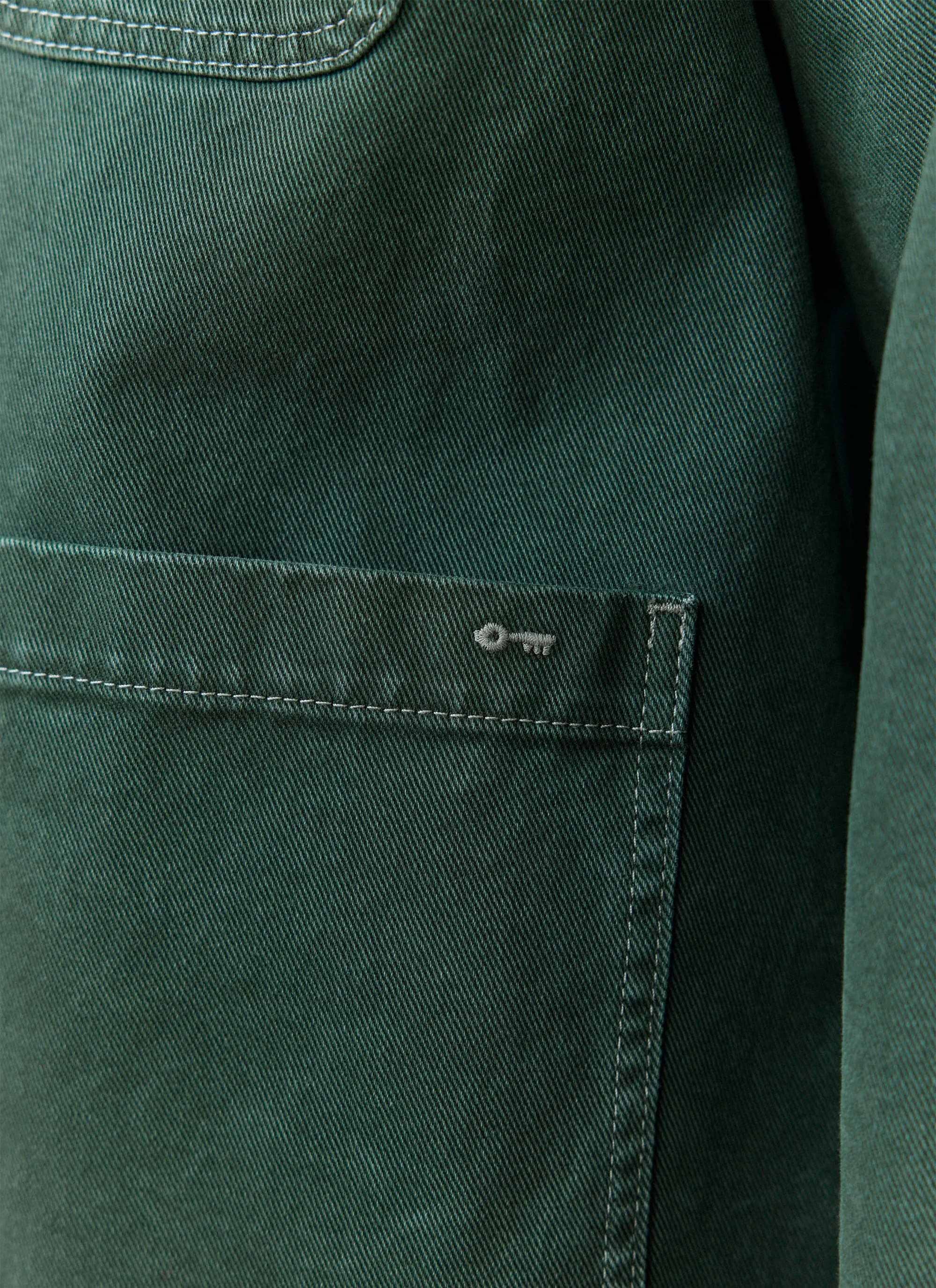 Forest green cotton canvas detail of the Percival Oliver Chore Jacket, showing the signature key embroidery on the pocket.