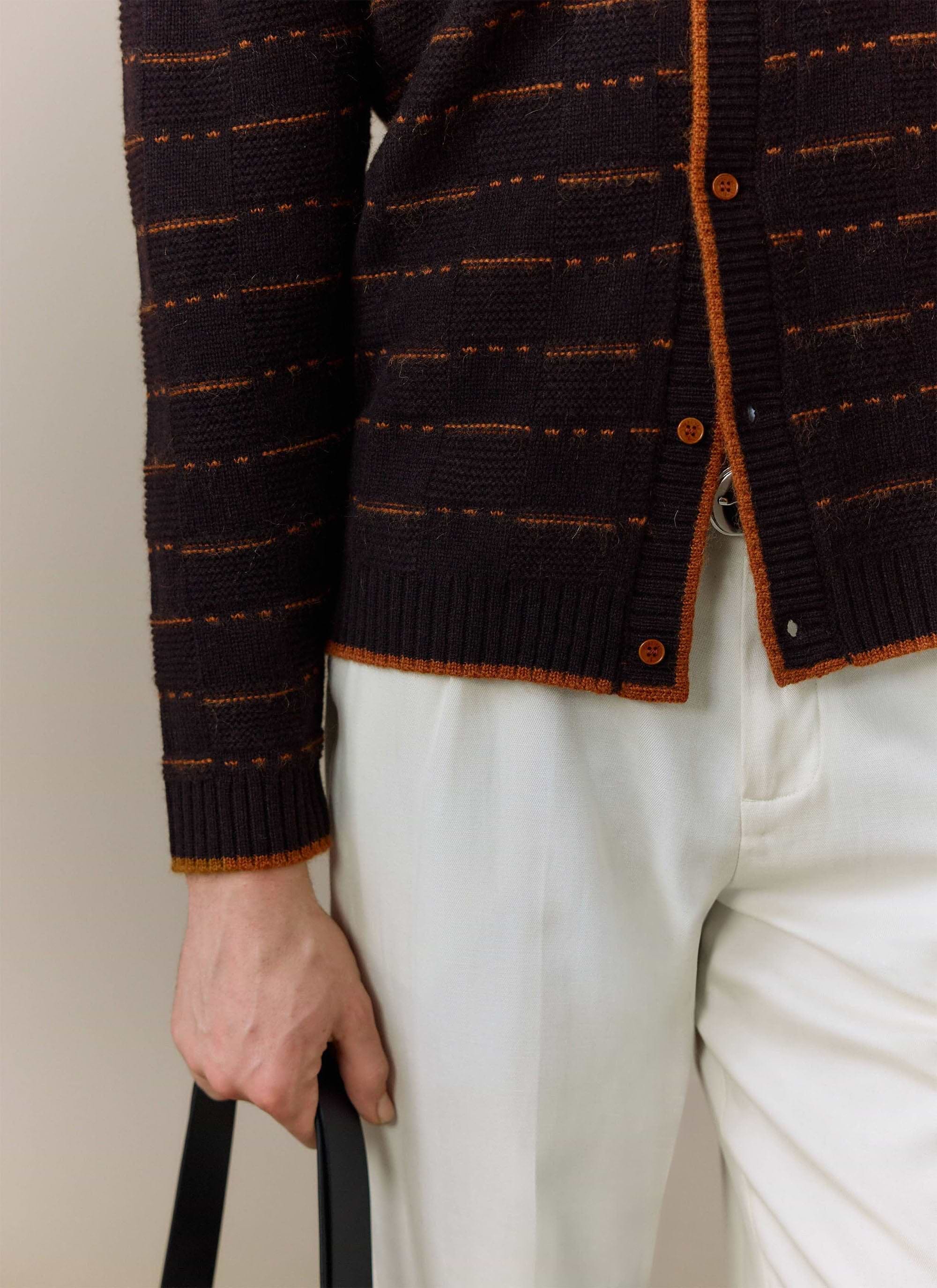 A close-up of a model wearing the brown Addison Knitted Shirt from Percival, showing the knit texture and orange details.