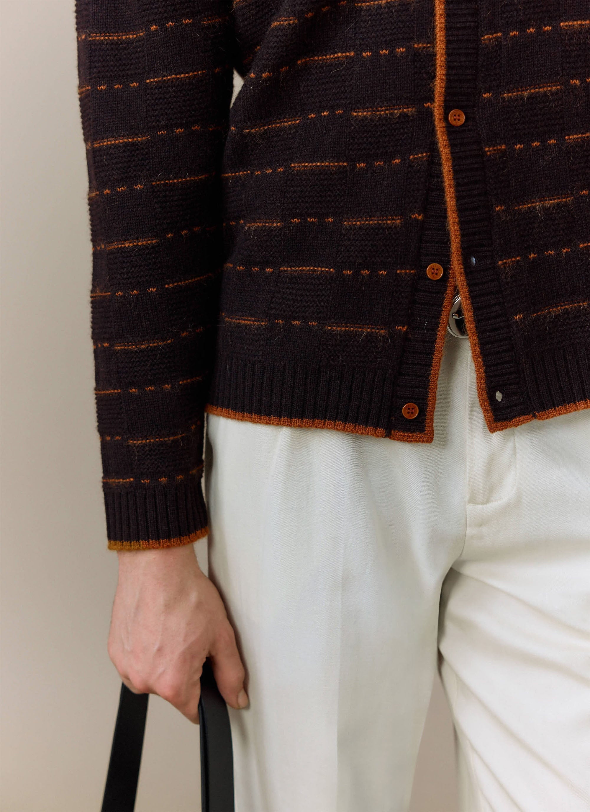 A close-up of a model wearing the brown Addison Knitted Shirt from Percival, showing the knit texture and orange details.