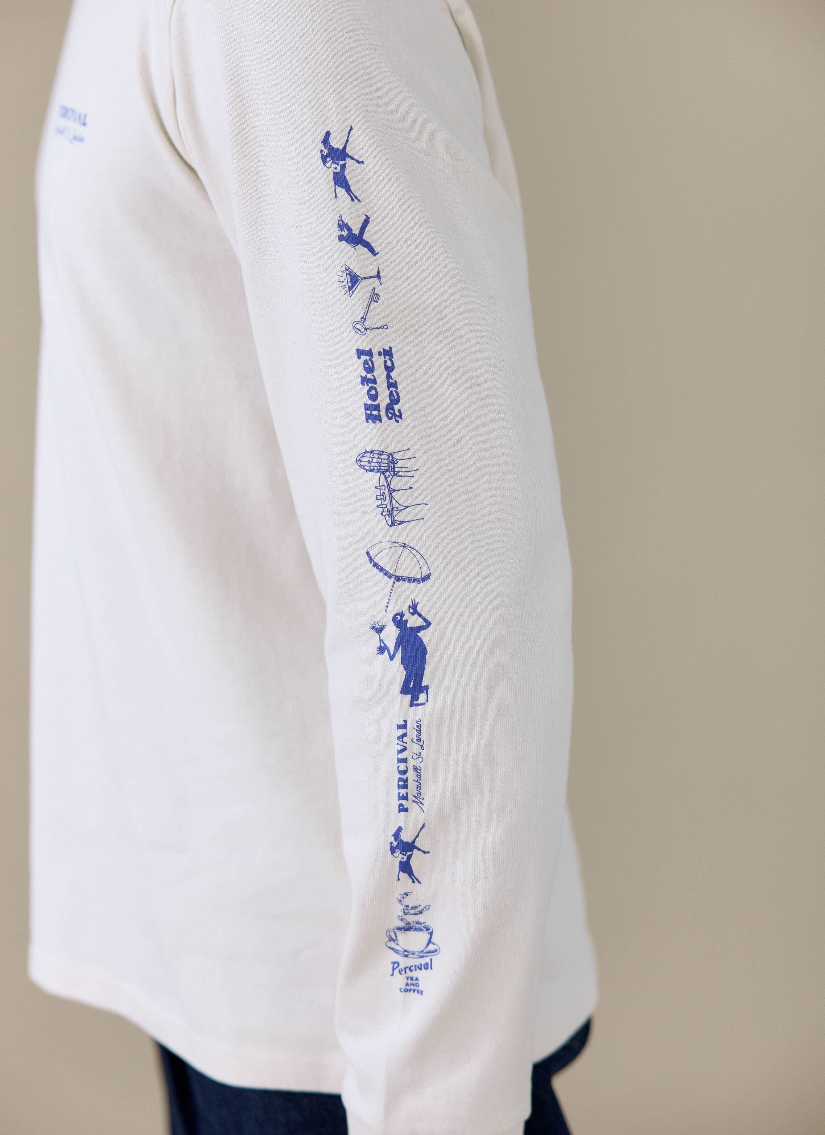 Close-up of the blue graphic print on the sleeve of the Percival Harlow Fine Wines long sleeve T-shirt in cream.