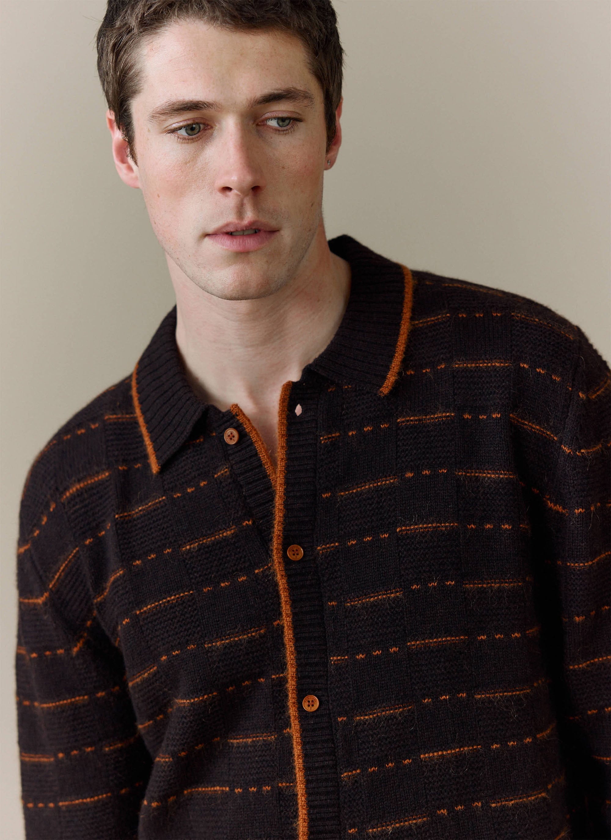 A close-up of a model wearing the brown Addison Long Sleeve Regular Knitted Shirt from Percival, showing the knit detail.
