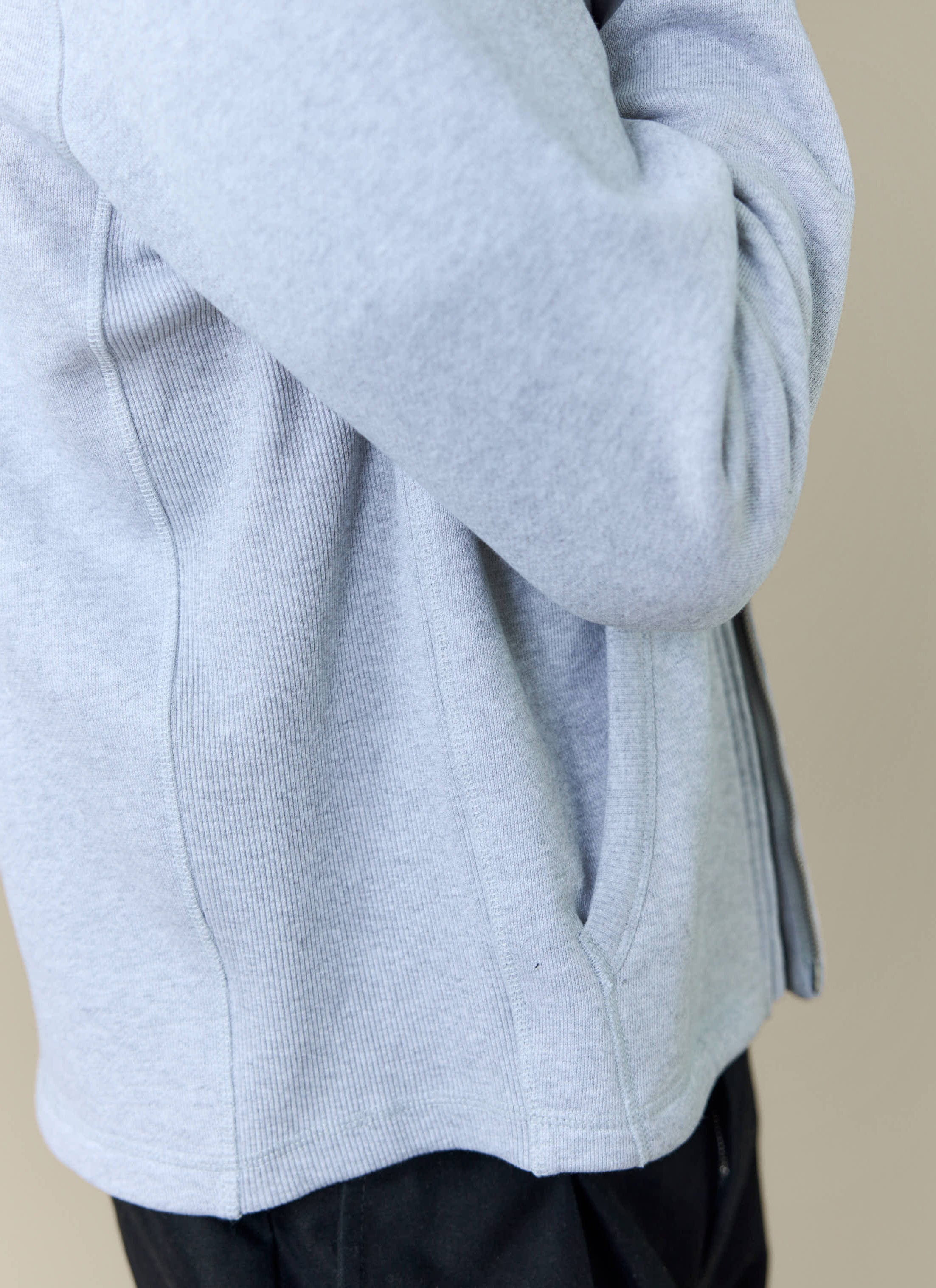 A close-up of the Percival Curtis Boxy Funnel Neck Sweatshirt in athletic grey, showing the side pocket and ribbed detail.