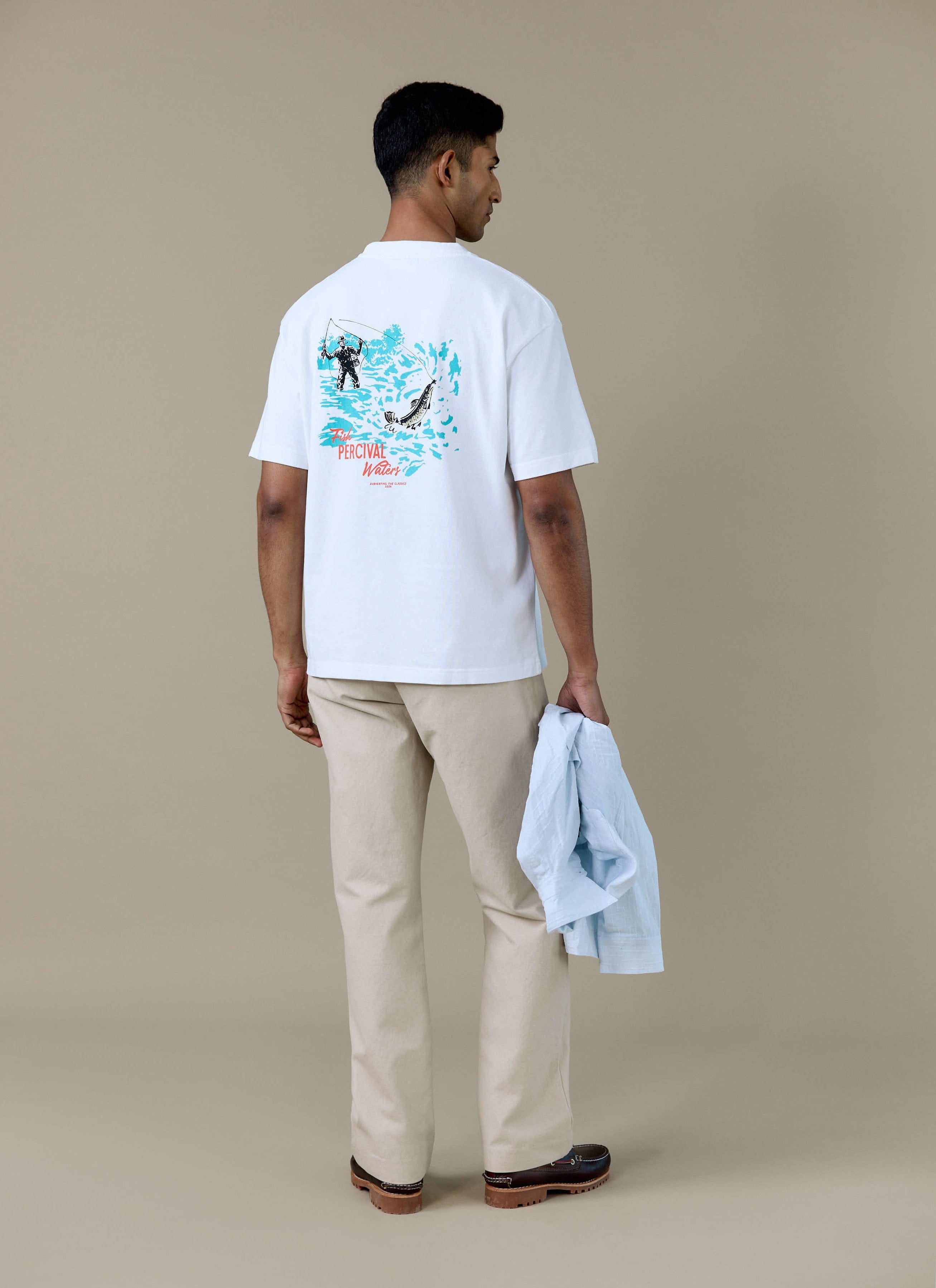 Rear view of a model in the white Percival Perci Waters Oversized T-shirt, showing the fisherman graphic on the back.