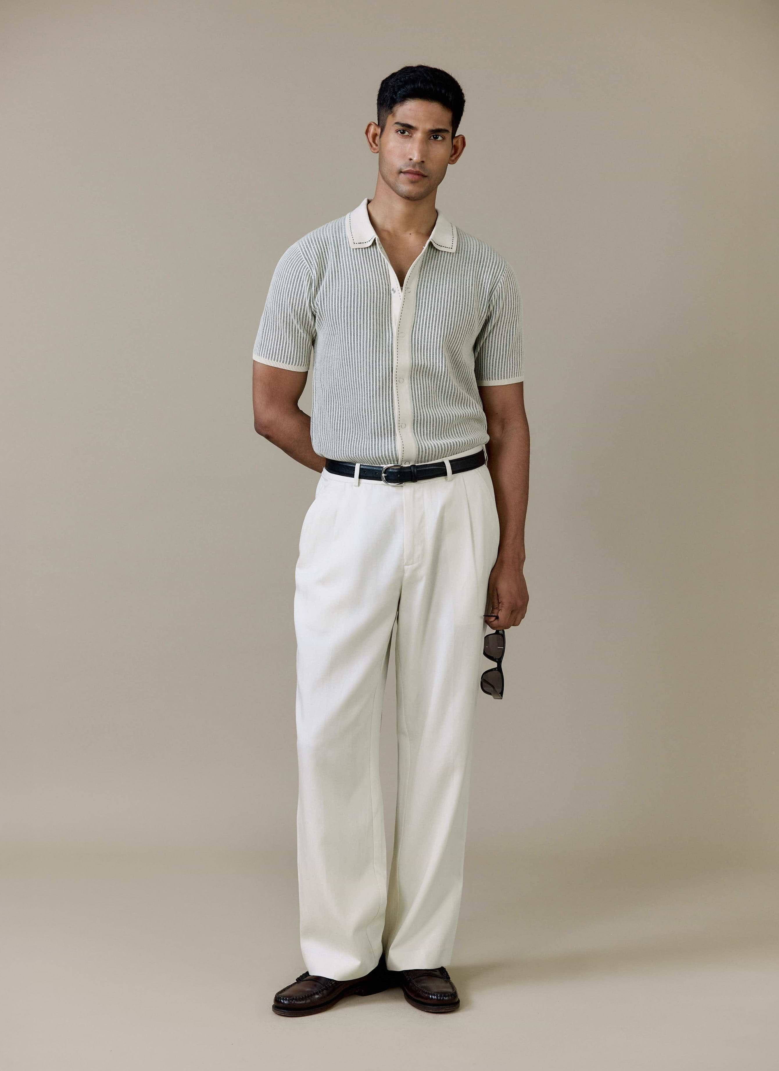 Model wearing the cream Percival Dixon Knitted Shirt with vertical stitch detail, styled with white trousers.