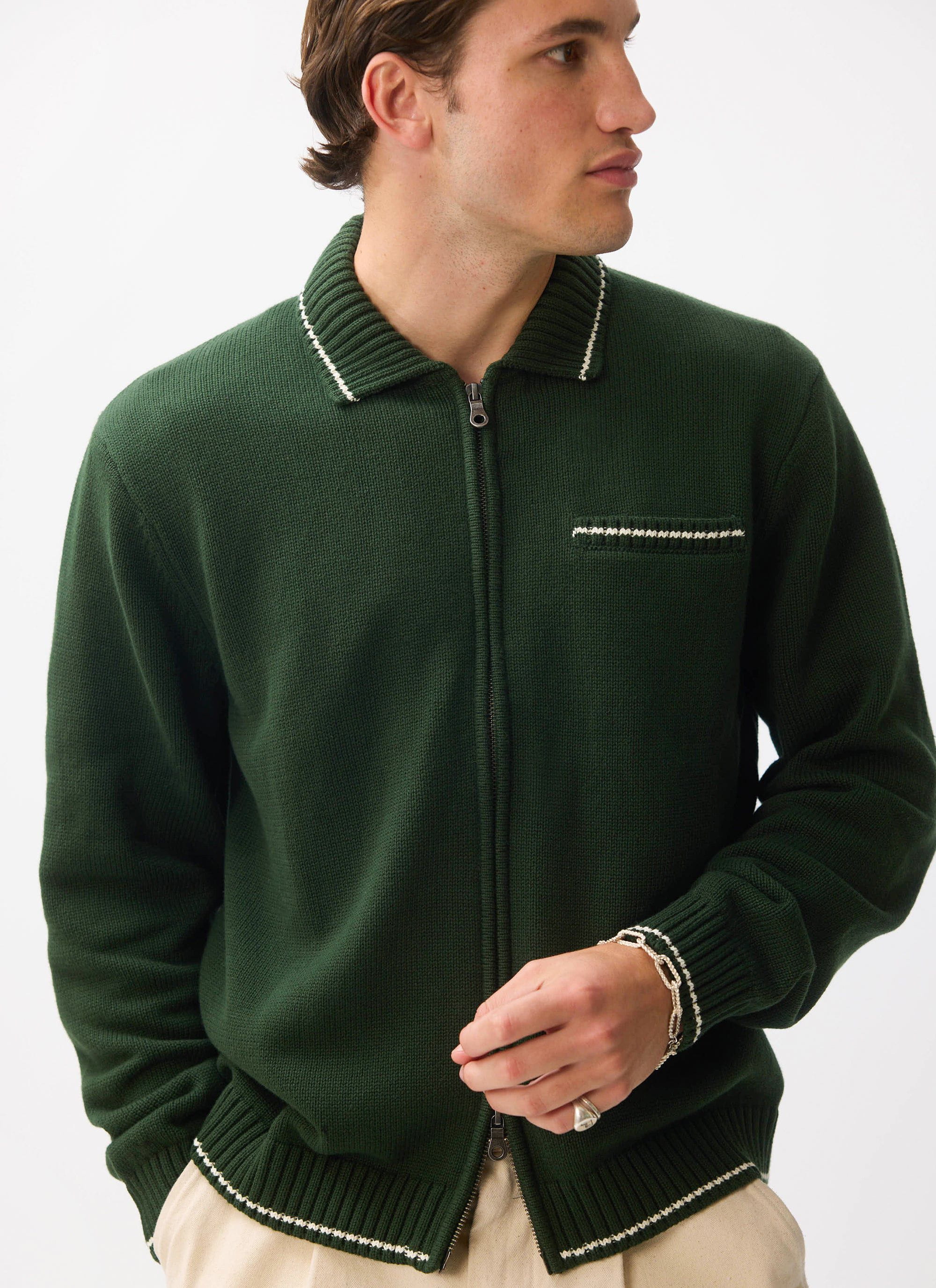 A model wears the Percival Gardner Knitted Zip Cardigan in forest green with contrast stitching on a white background.