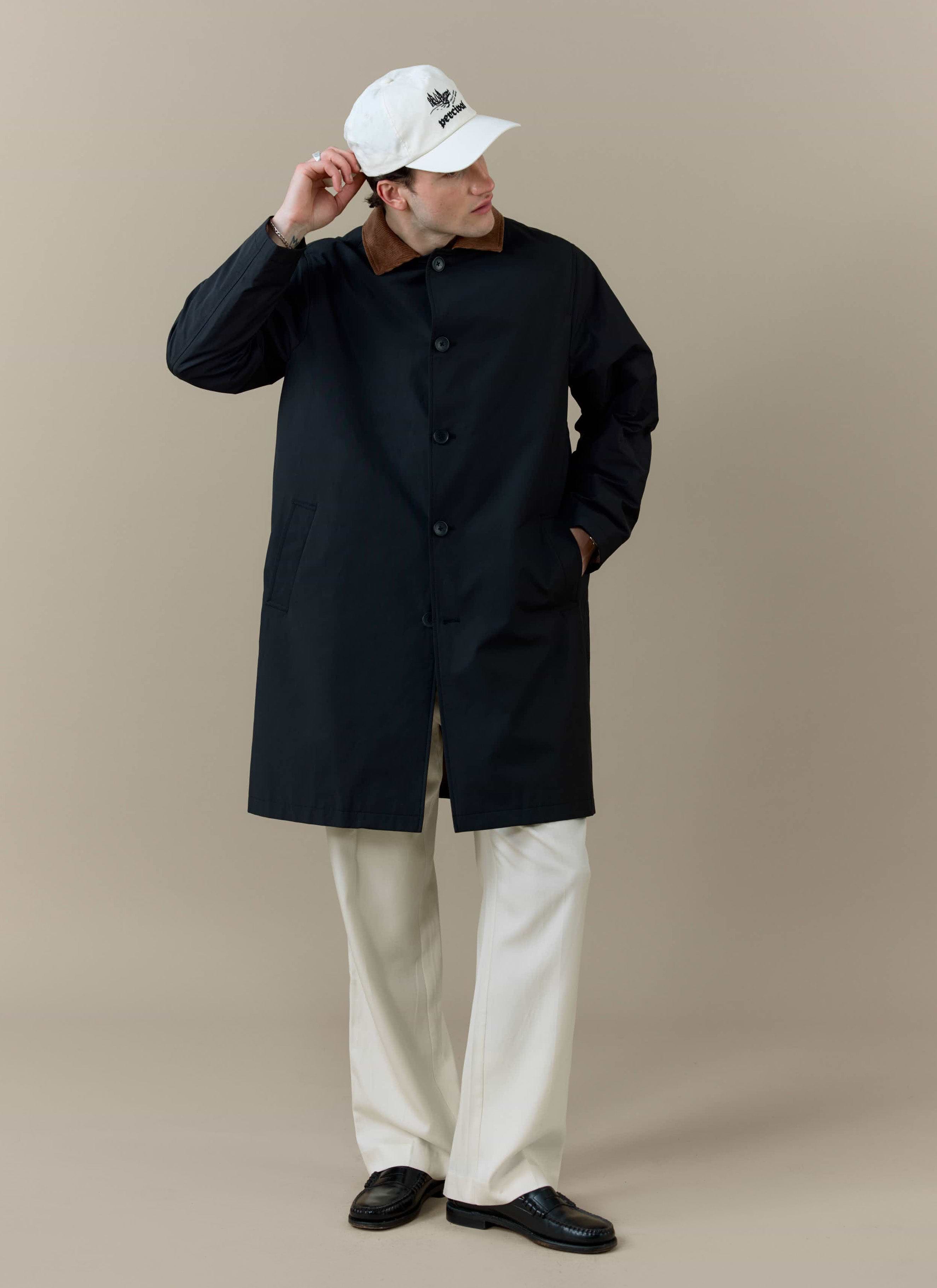 A model wearing the black Percival Cord Collar Relaxed Trench Coat with a contrast brown corduroy collar.