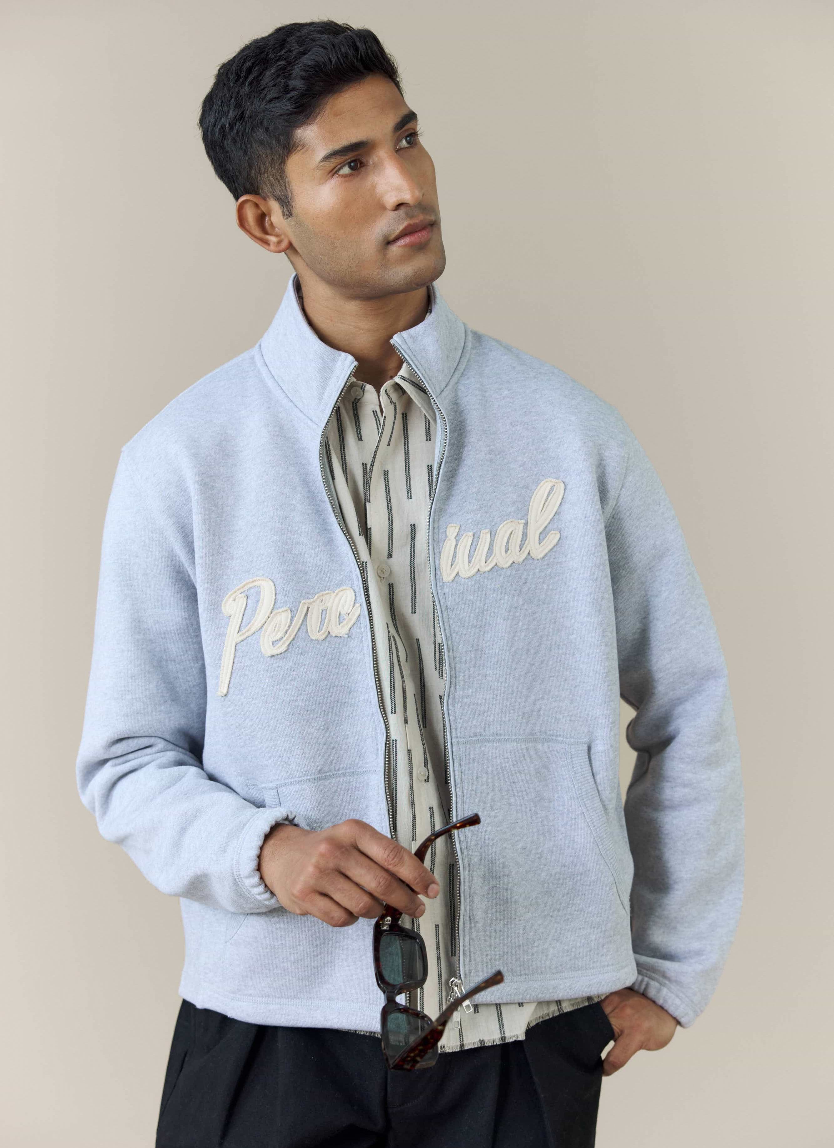 A model wears the athletic grey Curtis Boxy Zip Funnel Neck Sweatshirt by Percival, showing the textured chest logo.