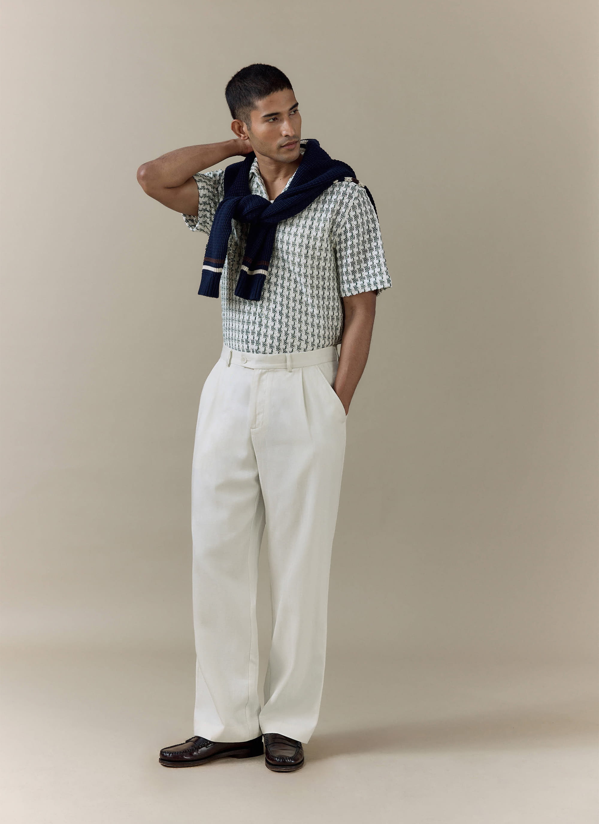 Percival Freddie Crochet Boxy Shirt in green cotton, styled with cream trousers and a navy knit over the shoulders.