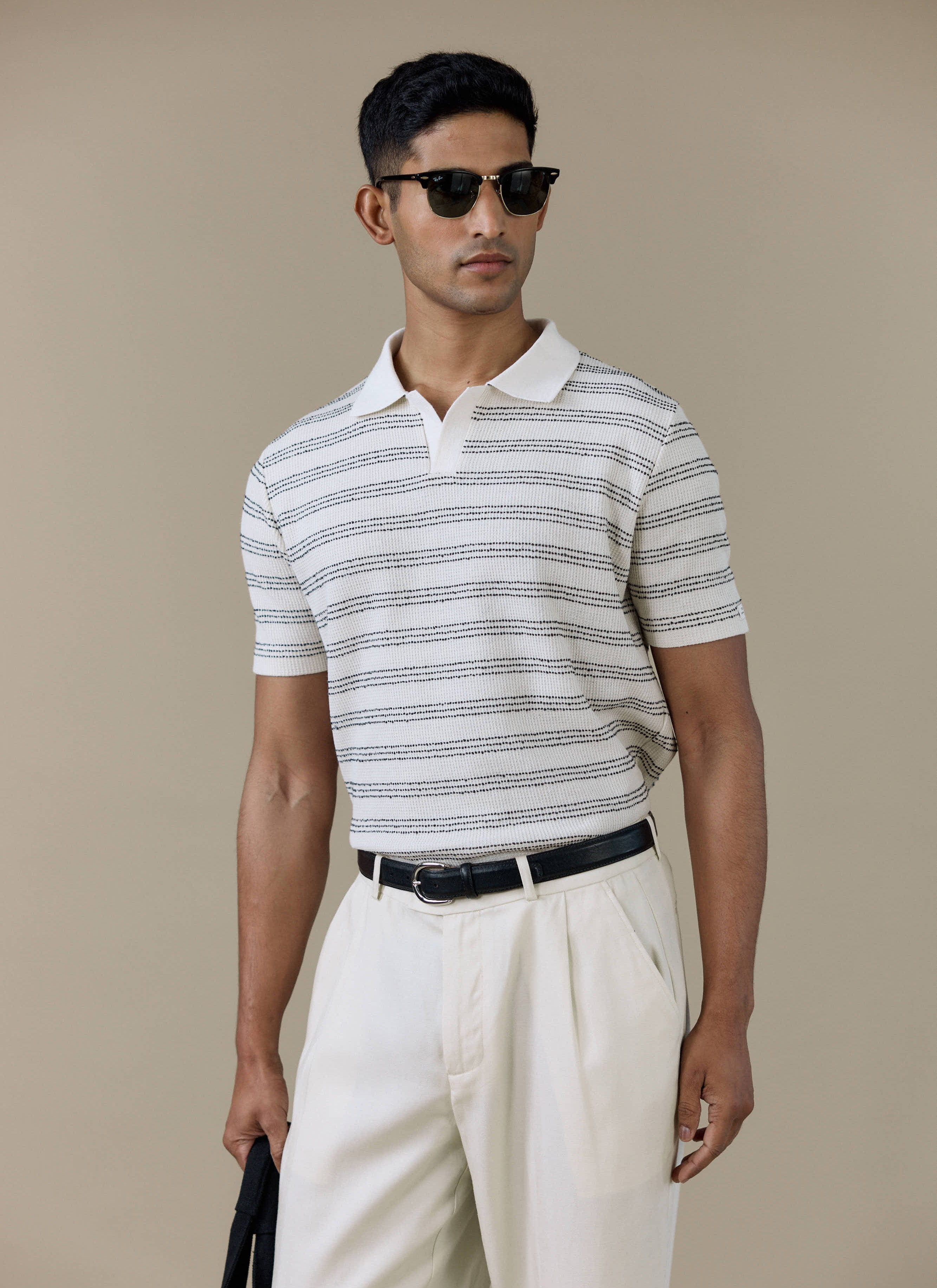 Model wearing the Percival Laurent Boxy Polo in cream, featuring horizontal stripes and an open collar.