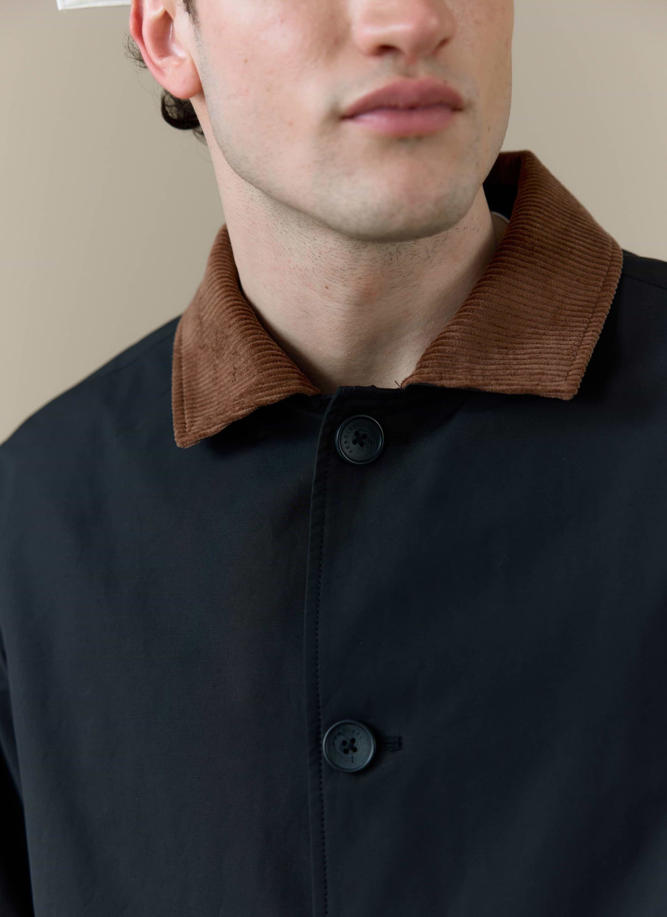 Close-up of the brown corduroy collar and top buttons on the Percival Cord Collar Relaxed Trench Coat in black.