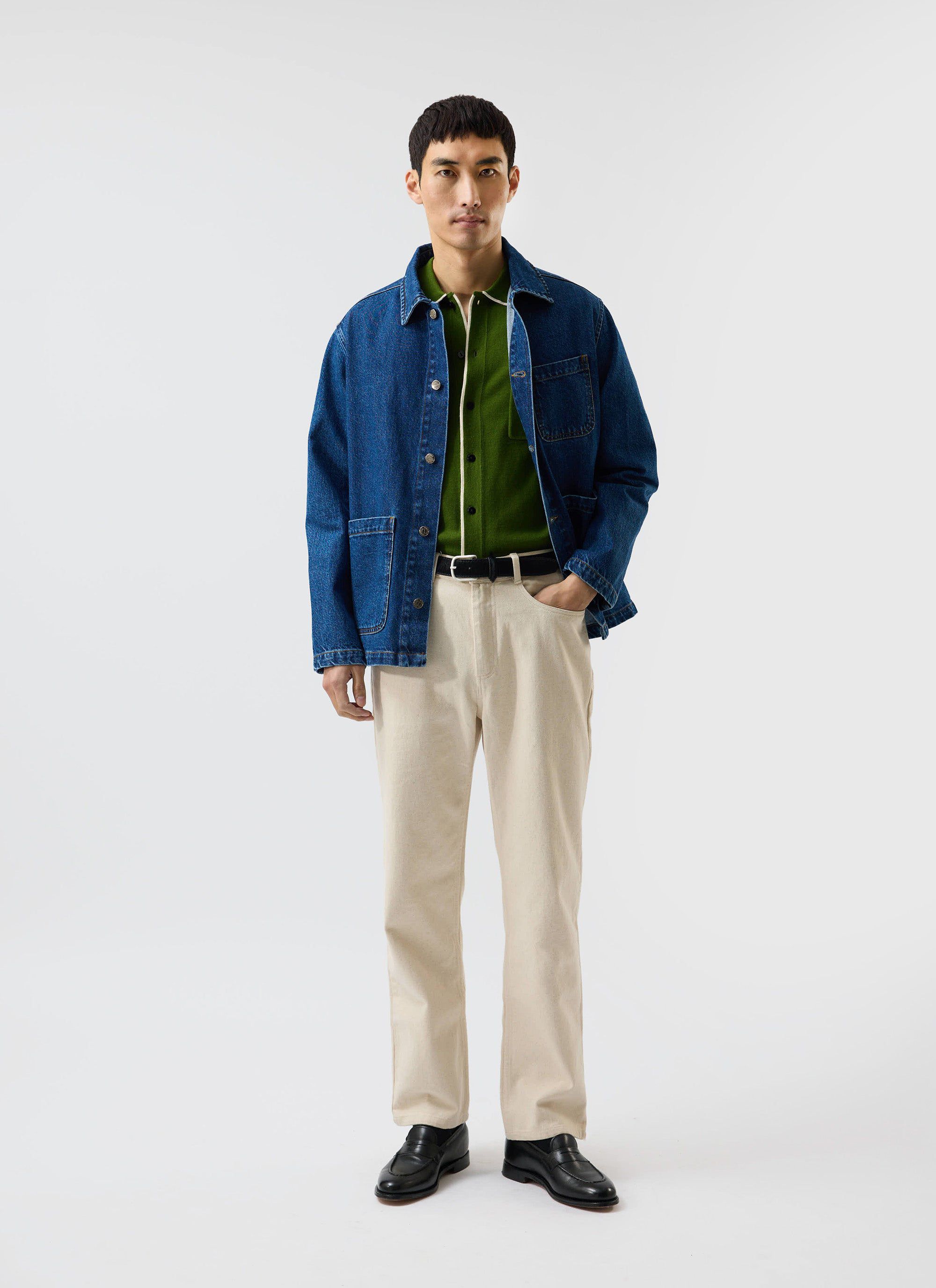 A model wears the Percival Contrast Trim Shirt in forest green under a denim jacket, with ecru trousers and loafers.
