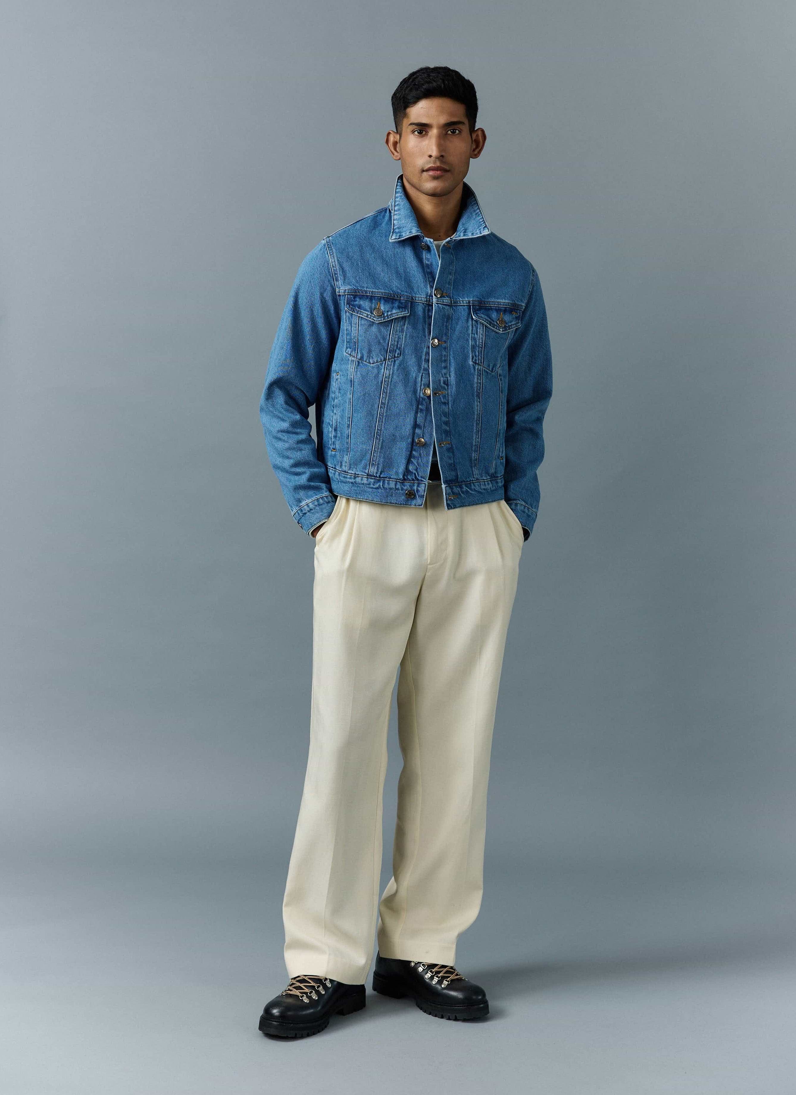 A model wears the Percival Western Trucker Jacket in light wash blue, styled with cream trousers and chunky black boots.