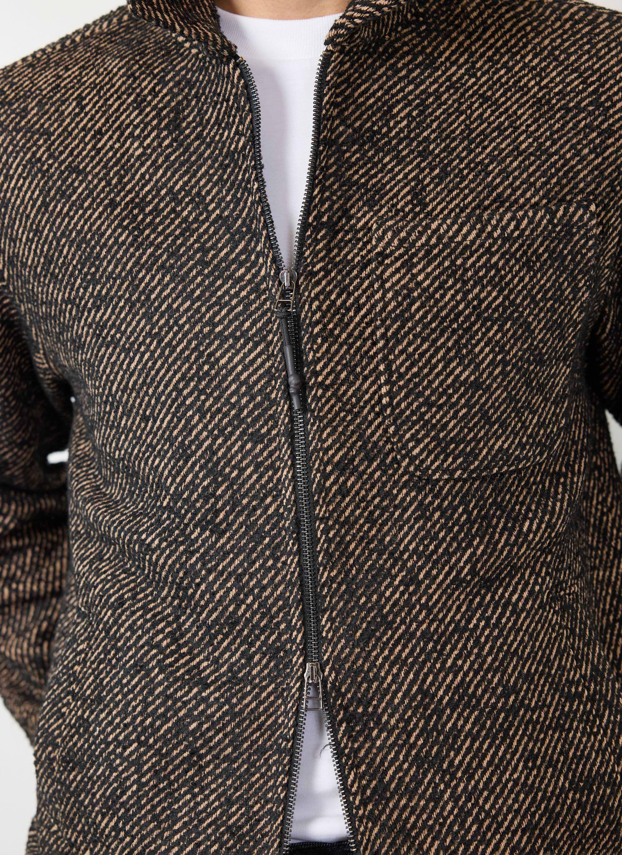 Close up of the Percival Zip Overshirt in Oak, detailing the black and brown twill weave and central zip.
