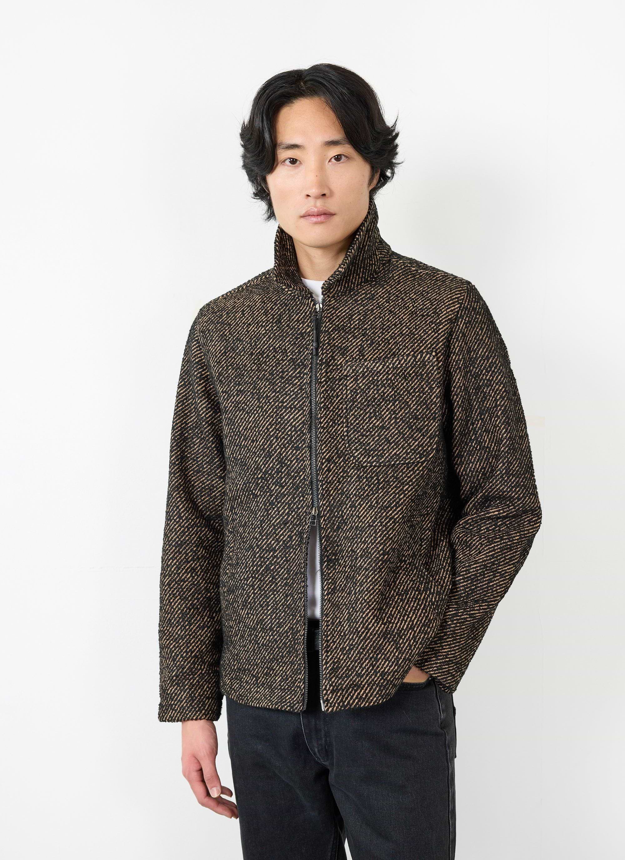 A model wears the Percival Zip Overshirt in Oak, a textured black and brown twill jacket with a front zip.