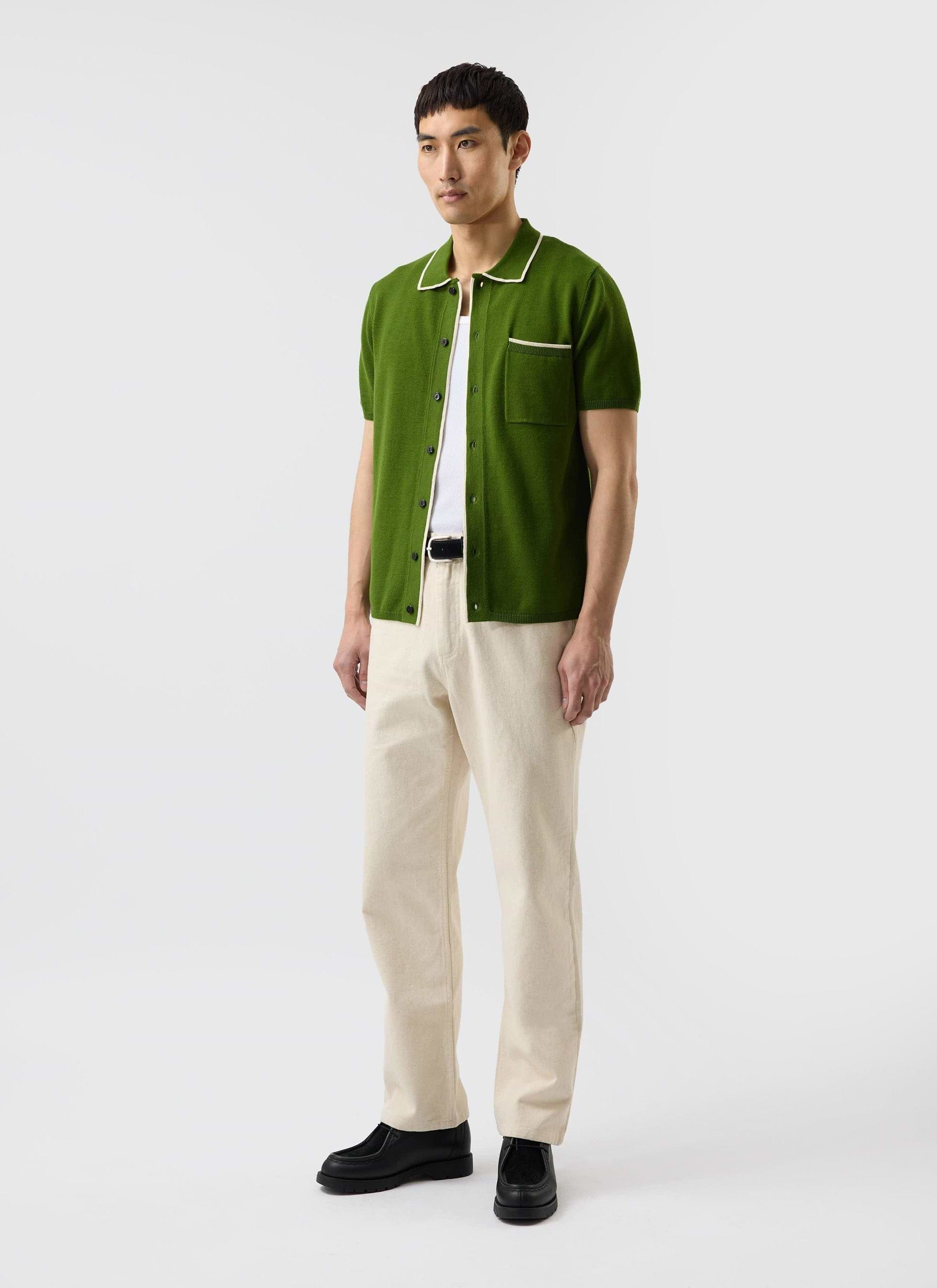 A man models the Percival Contrast Trim Shirt in forest green, a wool-blend knit with ecru detailing.