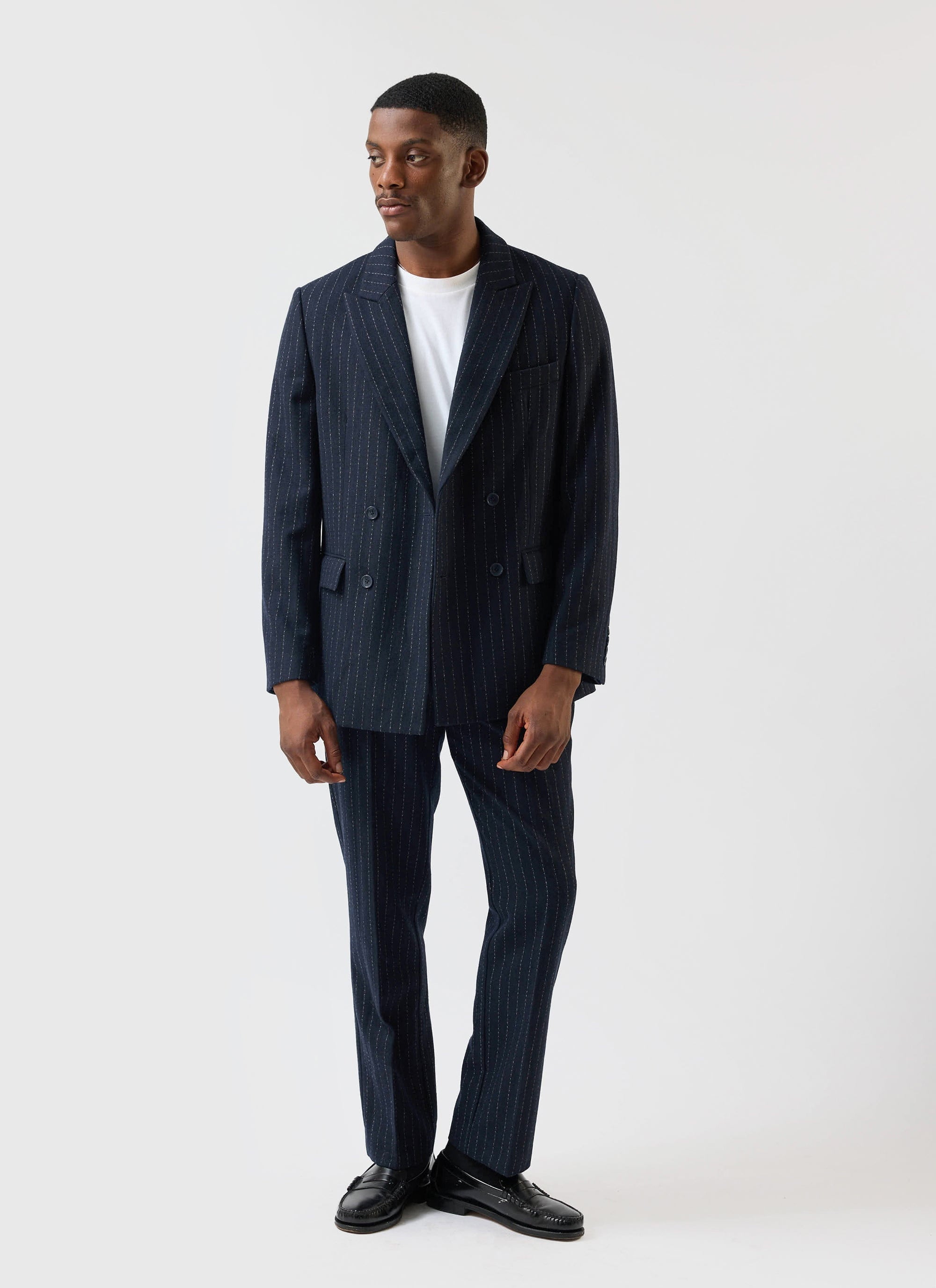 A model wears the Percival Textured Stripe Double Breasted Blazer in navy with matching trousers and a white t-shirt.