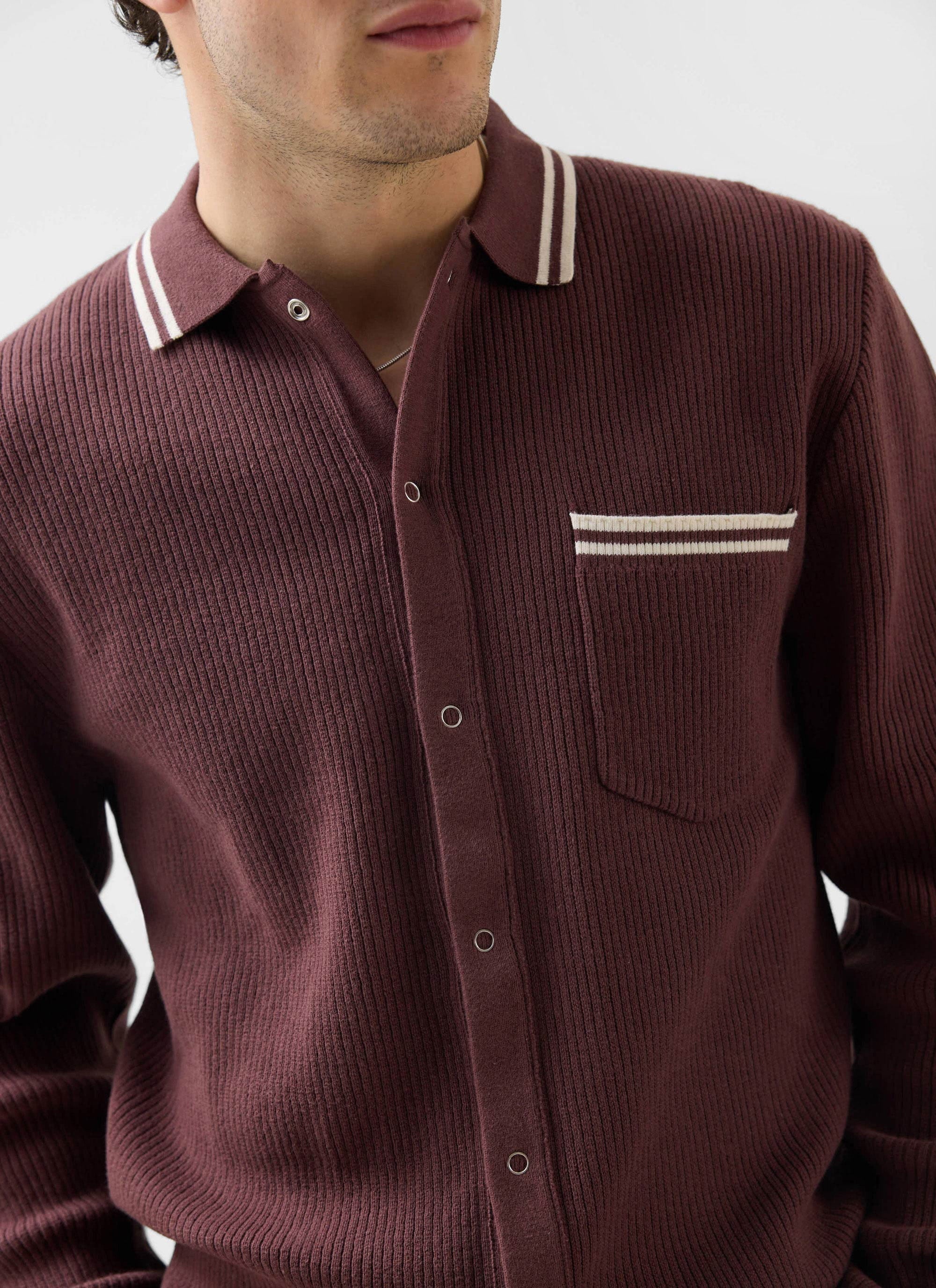 Close up of a model wearing the Percival Pablo cotton knitted shirt in espresso brown, showing the striped collar and pocket.