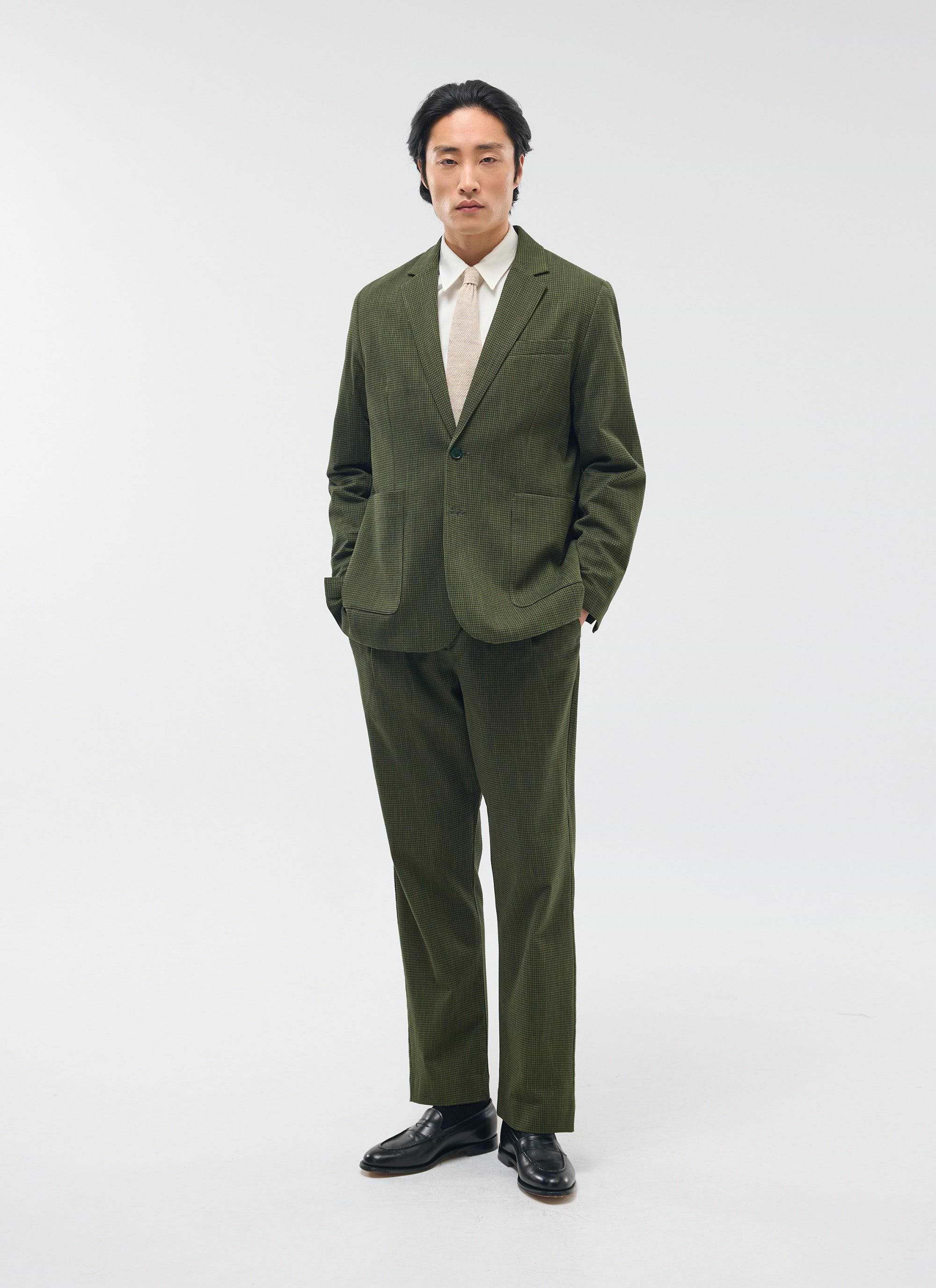 A model wears the Percival Pleated Tailored Trousers in a forest green micro check, styled with the matching suit jacket.