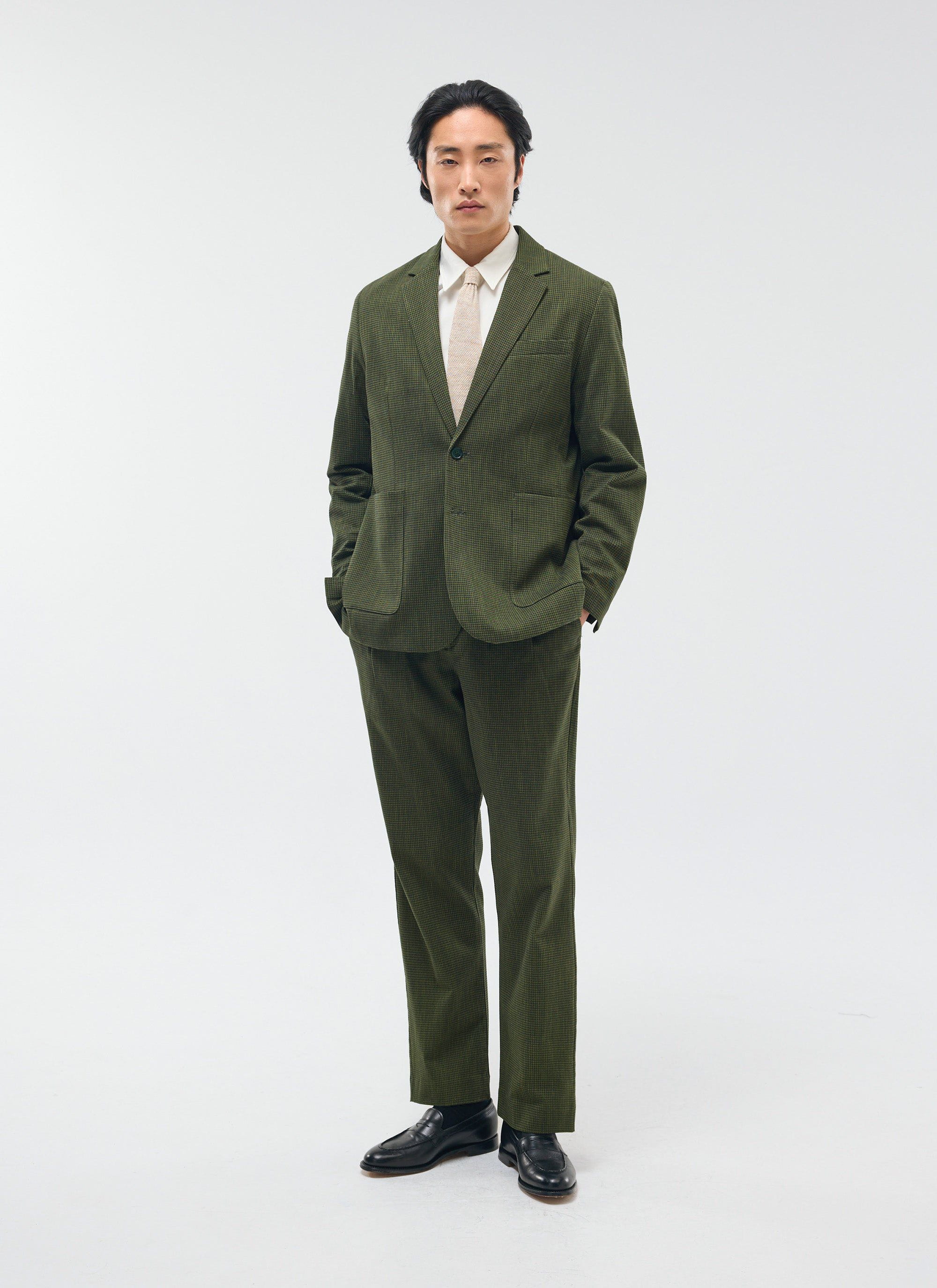 A model wears the Percival Pleated Tailored Trousers in a forest green micro check, styled with the matching suit jacket.