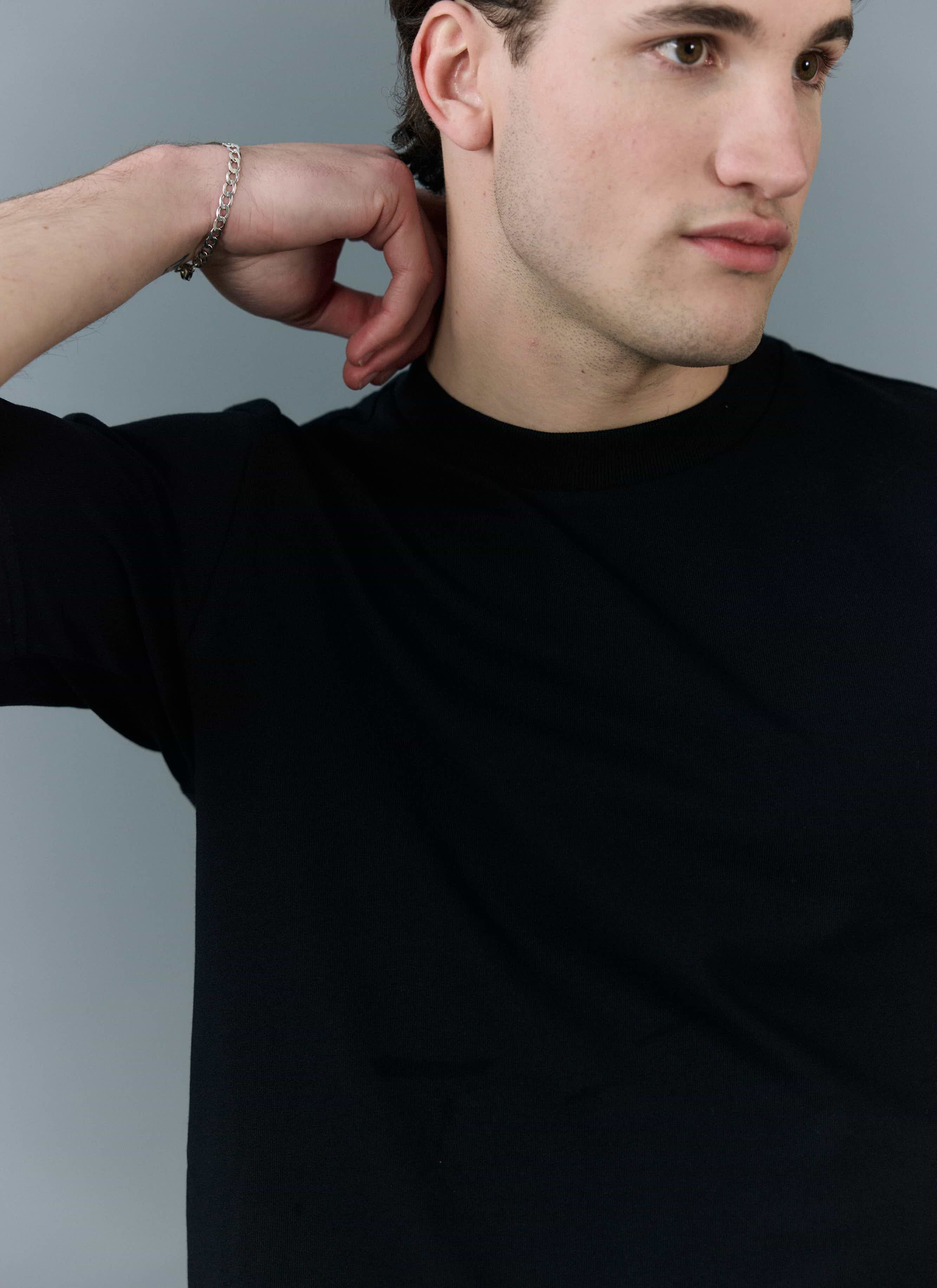 Close-up of a model wearing the black organic cotton Cropped Regular Fit T Shirt from Percival, showing the ribbed neckline.
