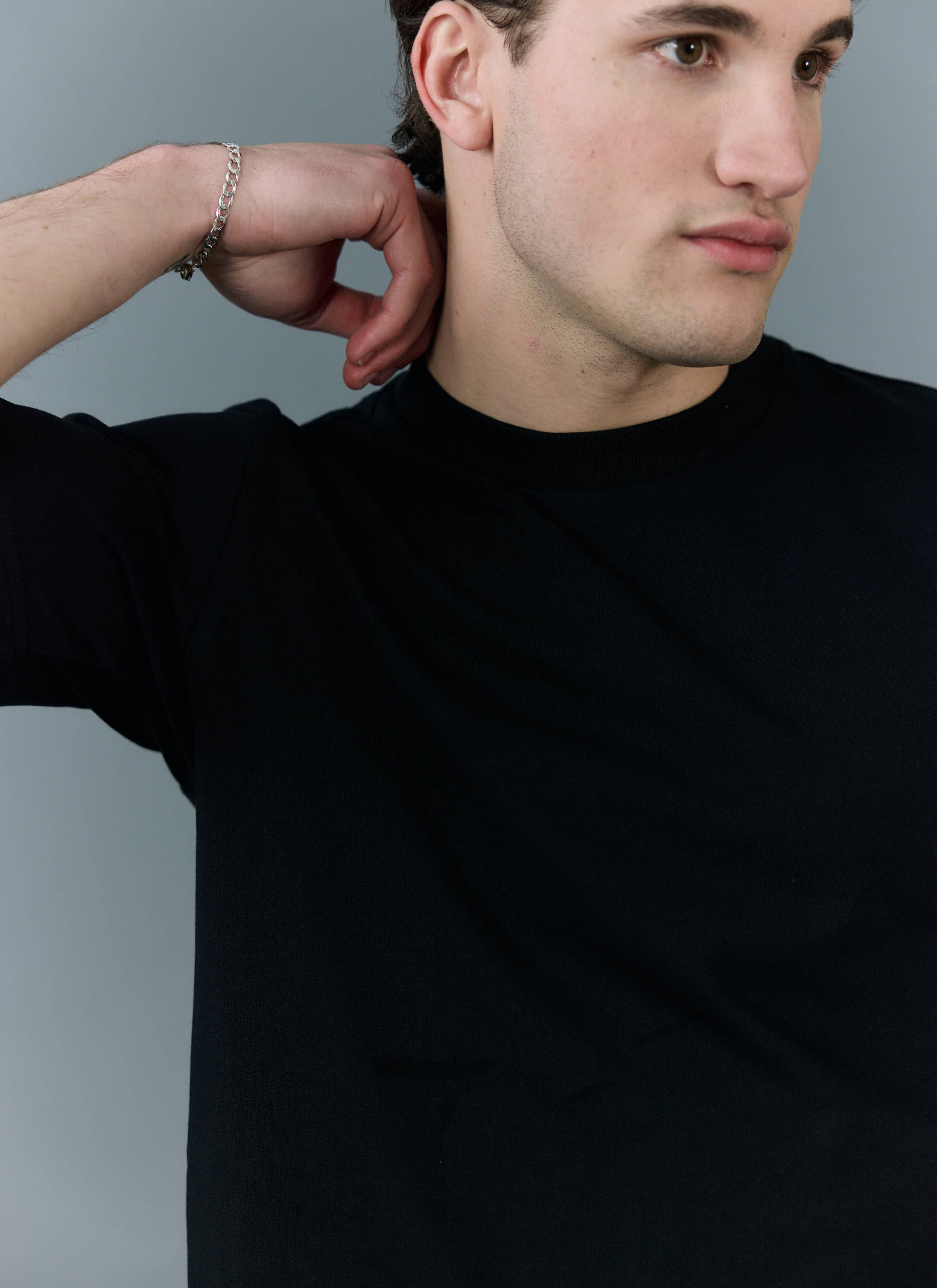 Close-up of a model wearing the black organic cotton Cropped Regular Fit T Shirt from Percival, showing the ribbed neckline.
