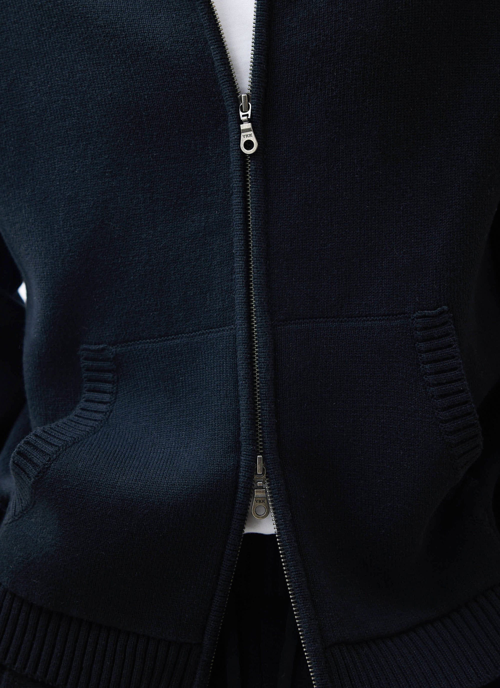 Close up of the Percival Chronicle Knitted Hoodie in black, showing the two-way zip and tight cotton knit.