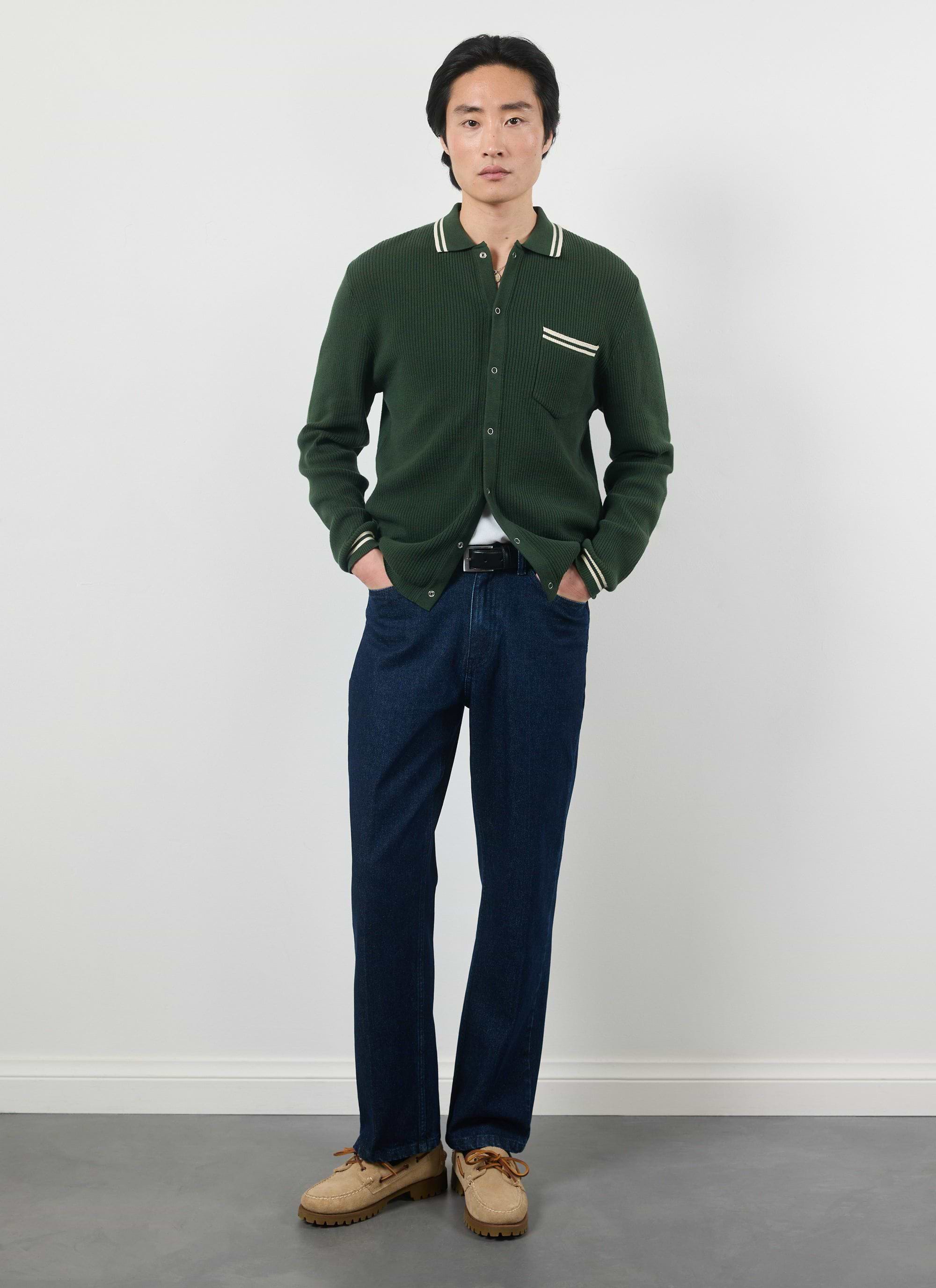 Model wearing the Percival forest green Pablo knitted shirt with dark denim and tan boat shoes.