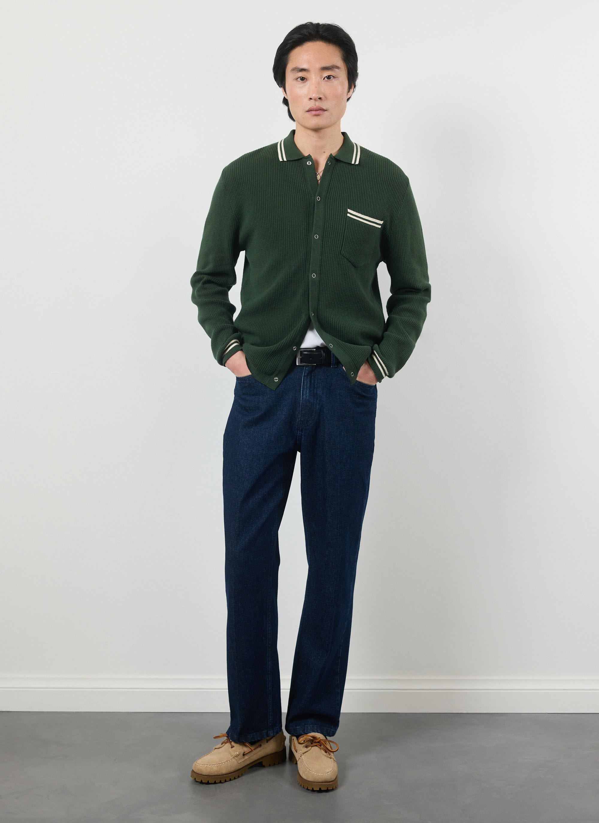 Model wearing the Percival forest green Pablo knitted shirt with dark denim and tan boat shoes.