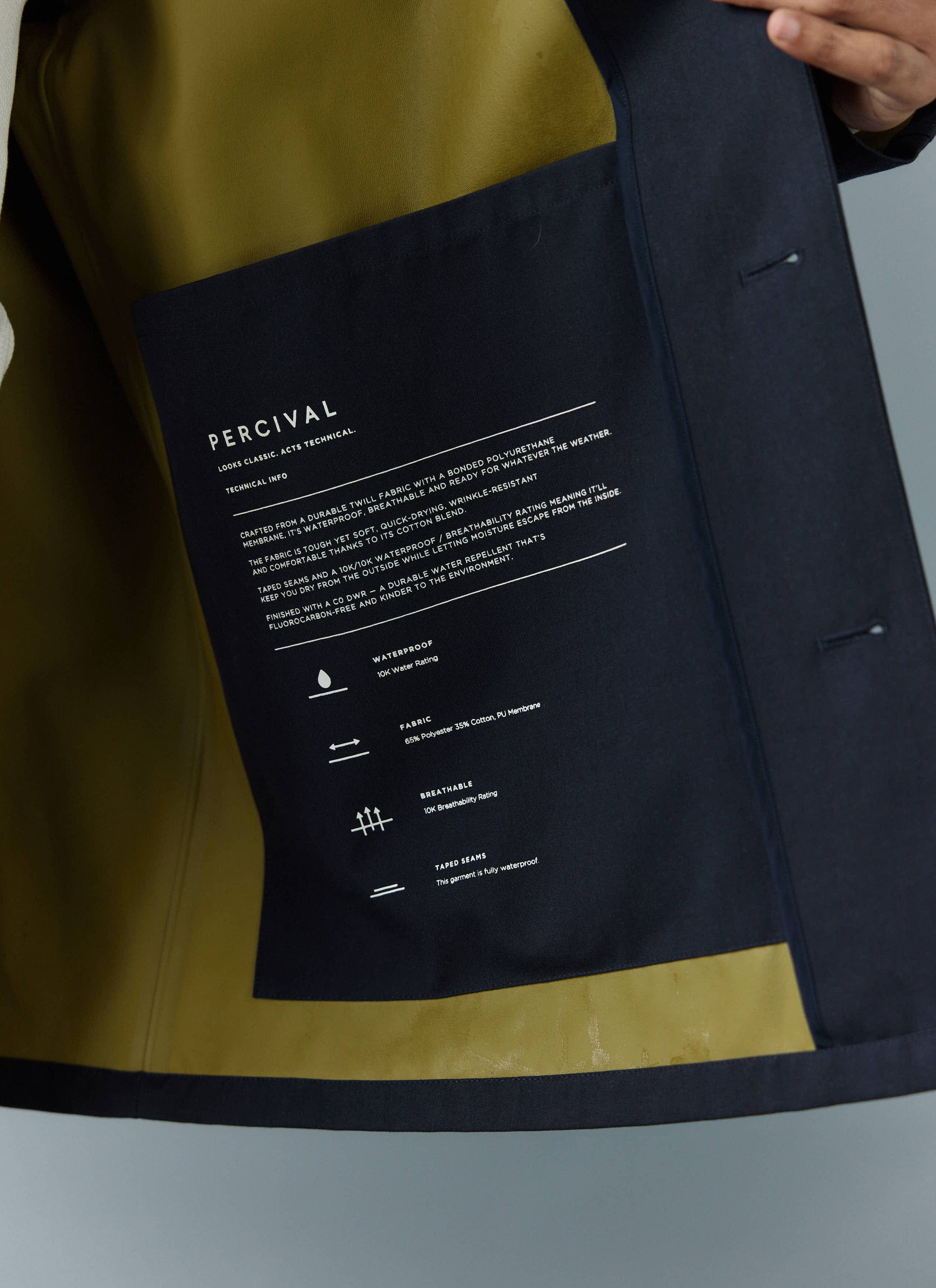A close-up of the technical information printed on the large internal pocket of the Percival Sherlock Trench Coat.