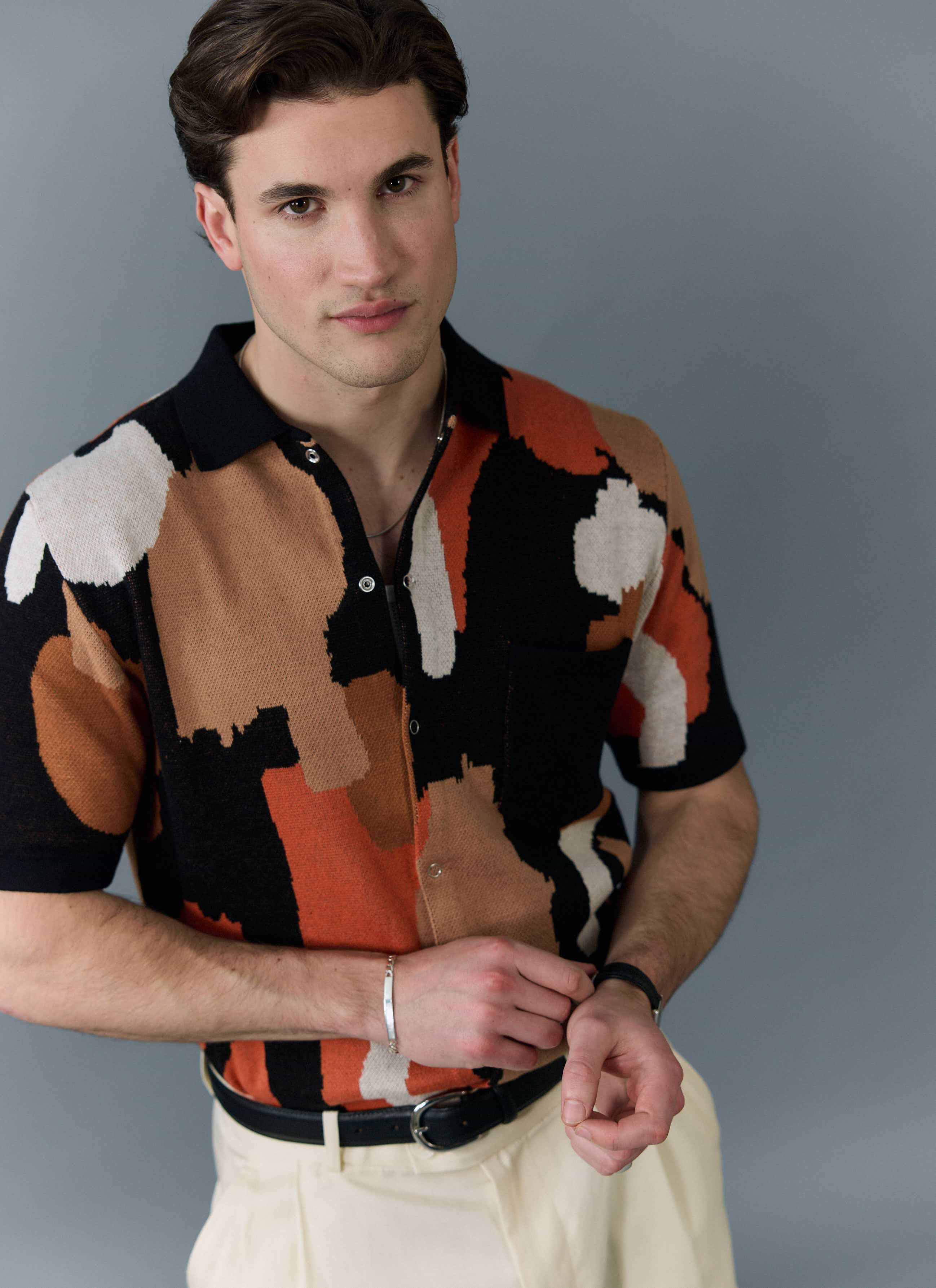 A model wears the Impressionist Jacquard Shirt from Percival, a knitted cotton shirt with an abstract multi-colour pattern.