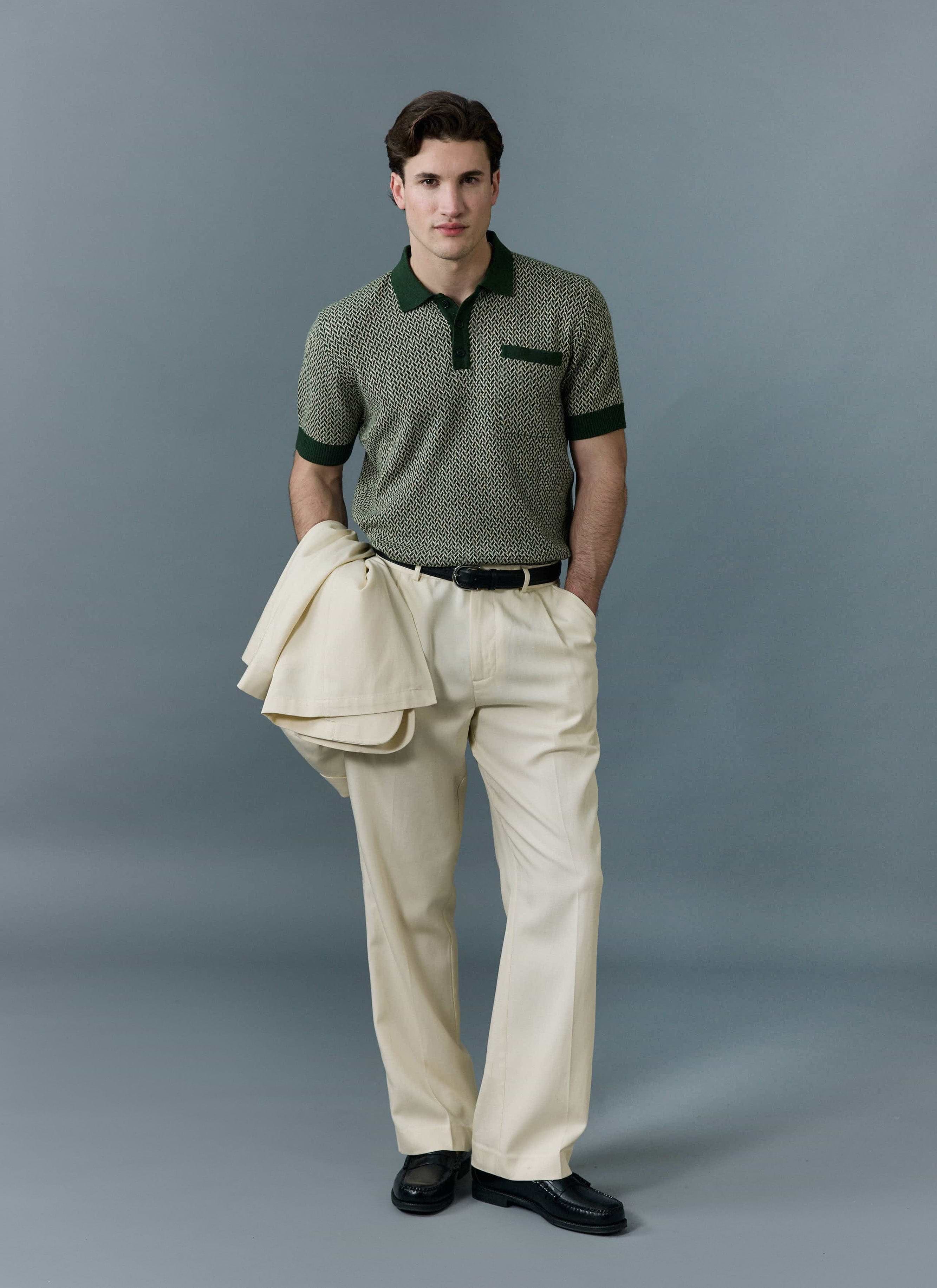 A model wears the Percival Casa Martini knitted polo in forest green with cream trousers, holding a matching cream jacket.