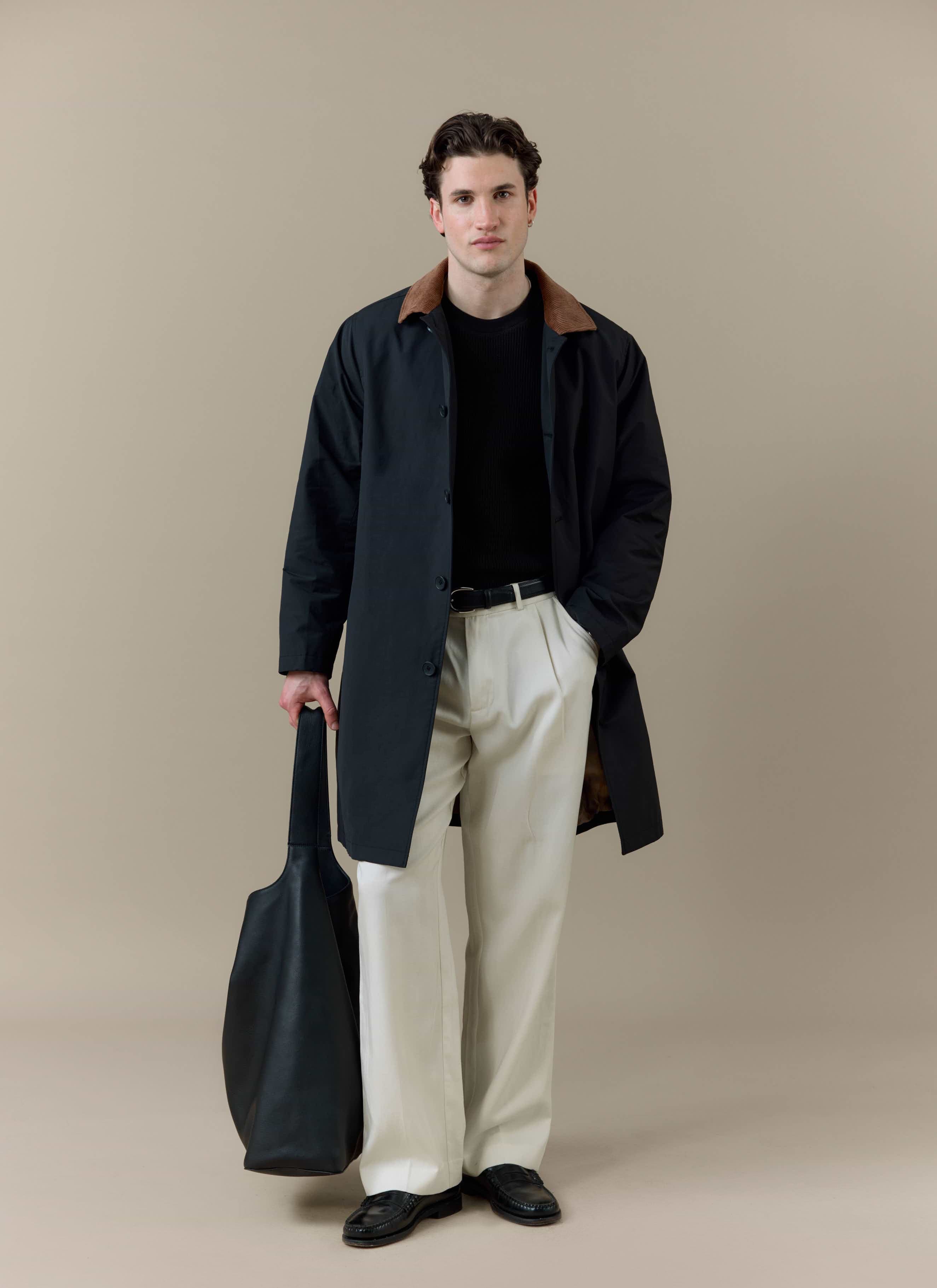 A model wearing the black Percival Cord Collar Relaxed Trench Coat featuring a contrast brown corduroy collar.