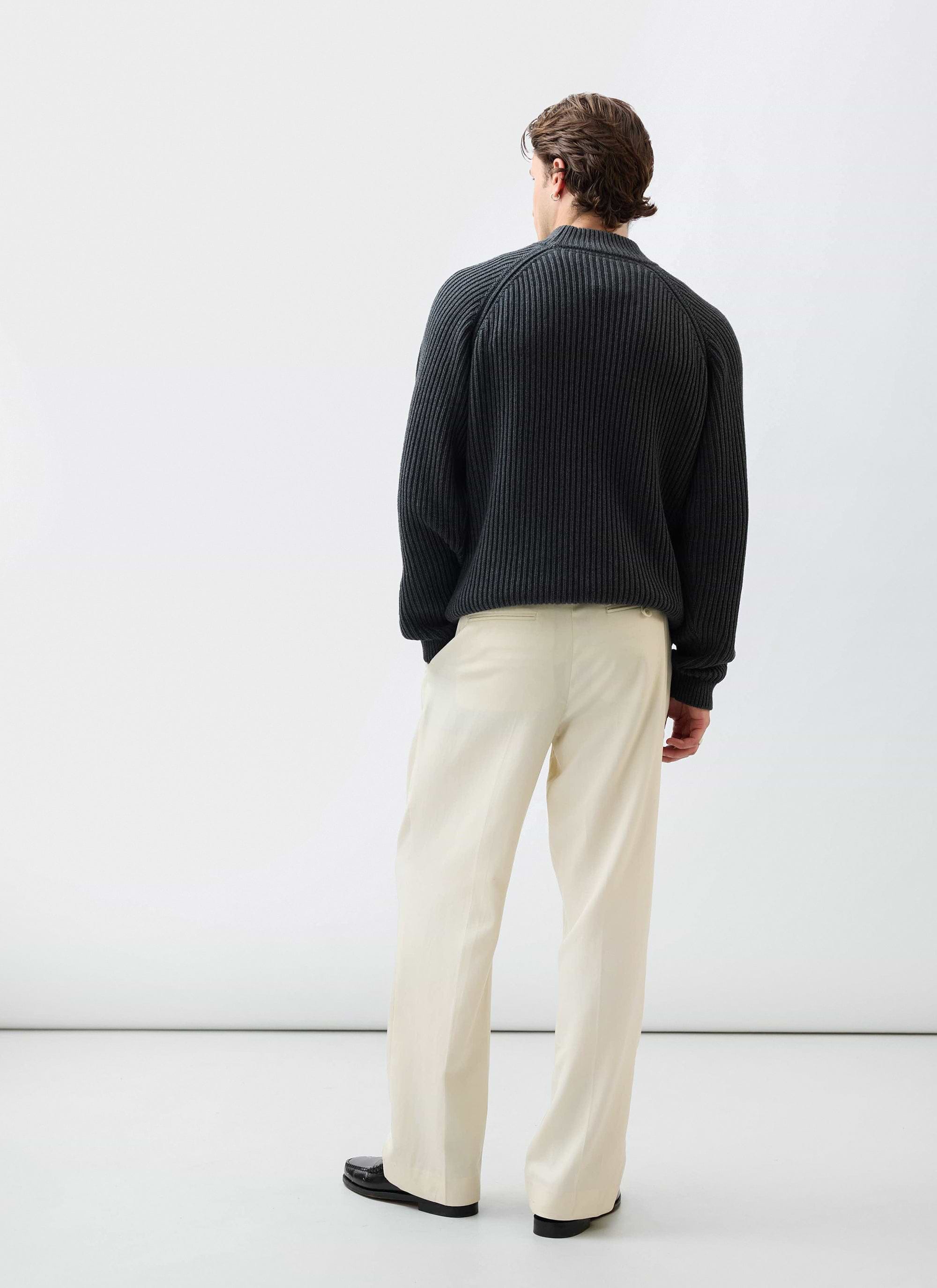 Back view of a model wearing the Percival Library Turtle Neck in charcoal, a ribbed cotton-wool blend jumper.