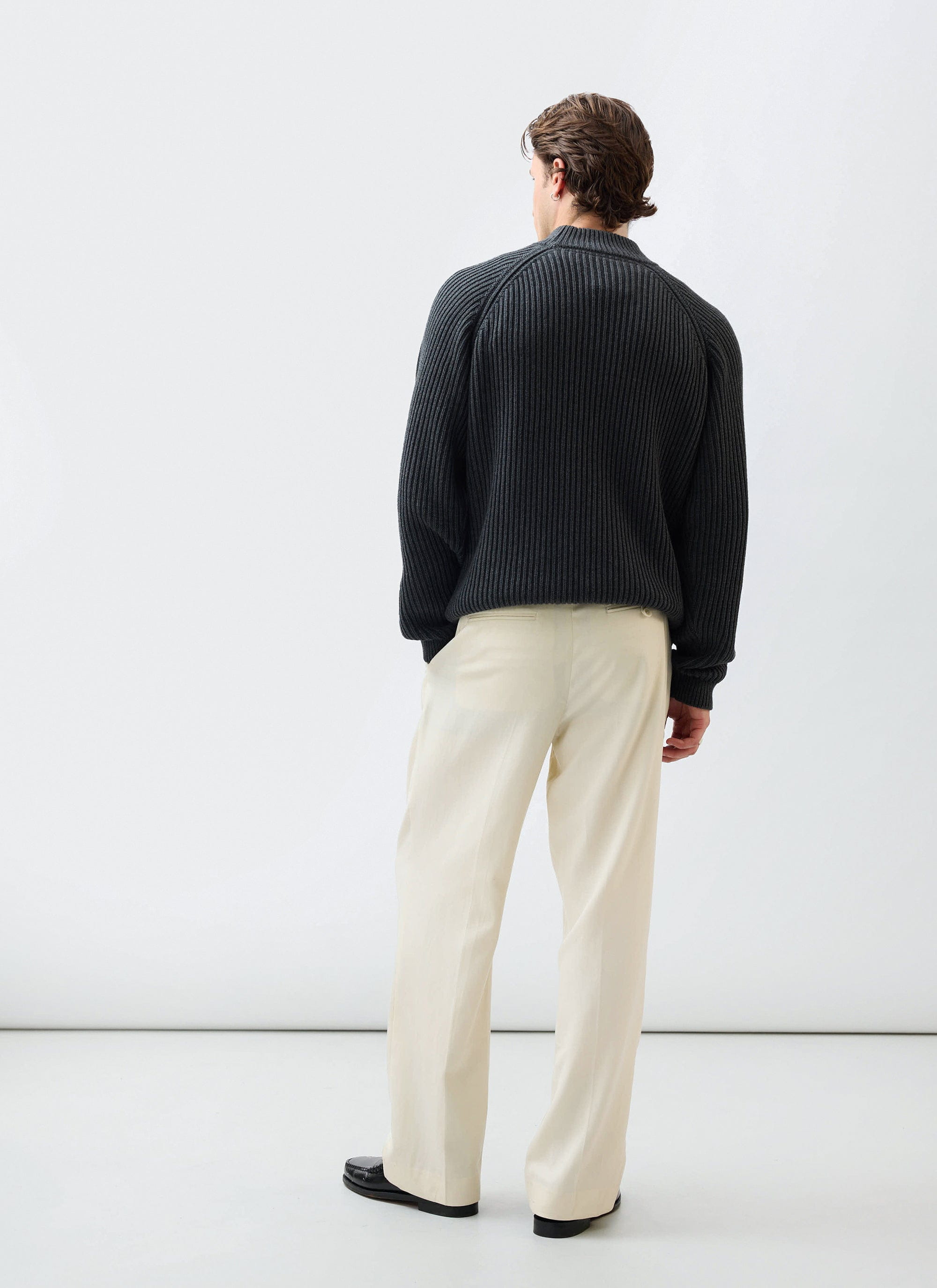 Back view of a model wearing the Percival Library Turtle Neck in charcoal, a ribbed cotton-wool blend jumper.
