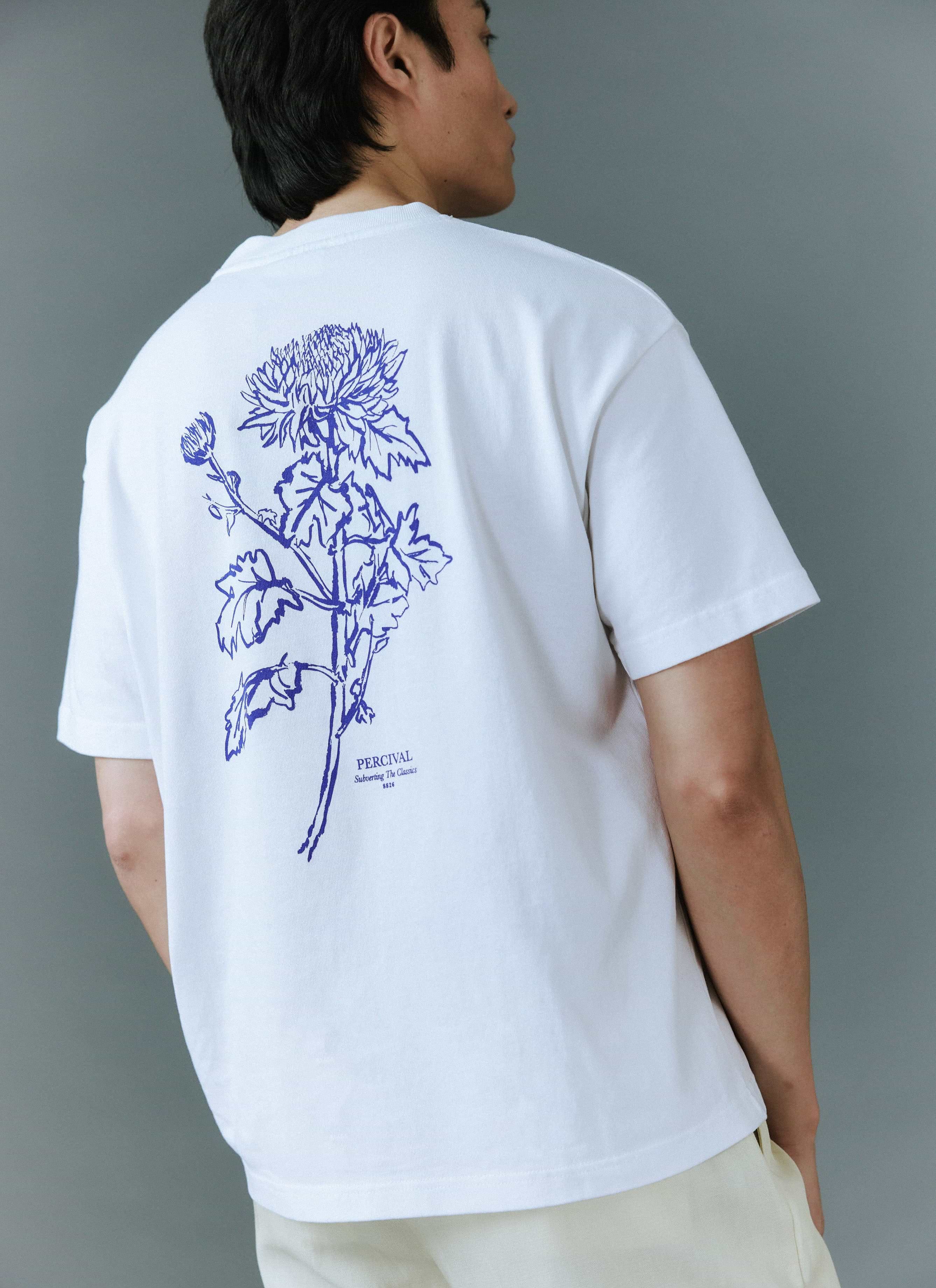 A model seen from behind wears the white Smith Floral t-shirt from Percival, showcasing the blue floral back graphic.