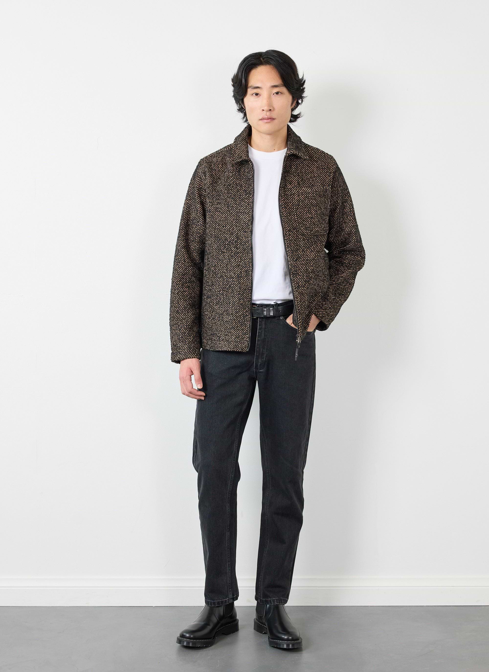 A model wears the Percival Zip Overshirt in Oak twill, layered over a white t-shirt with black jeans and black boots.