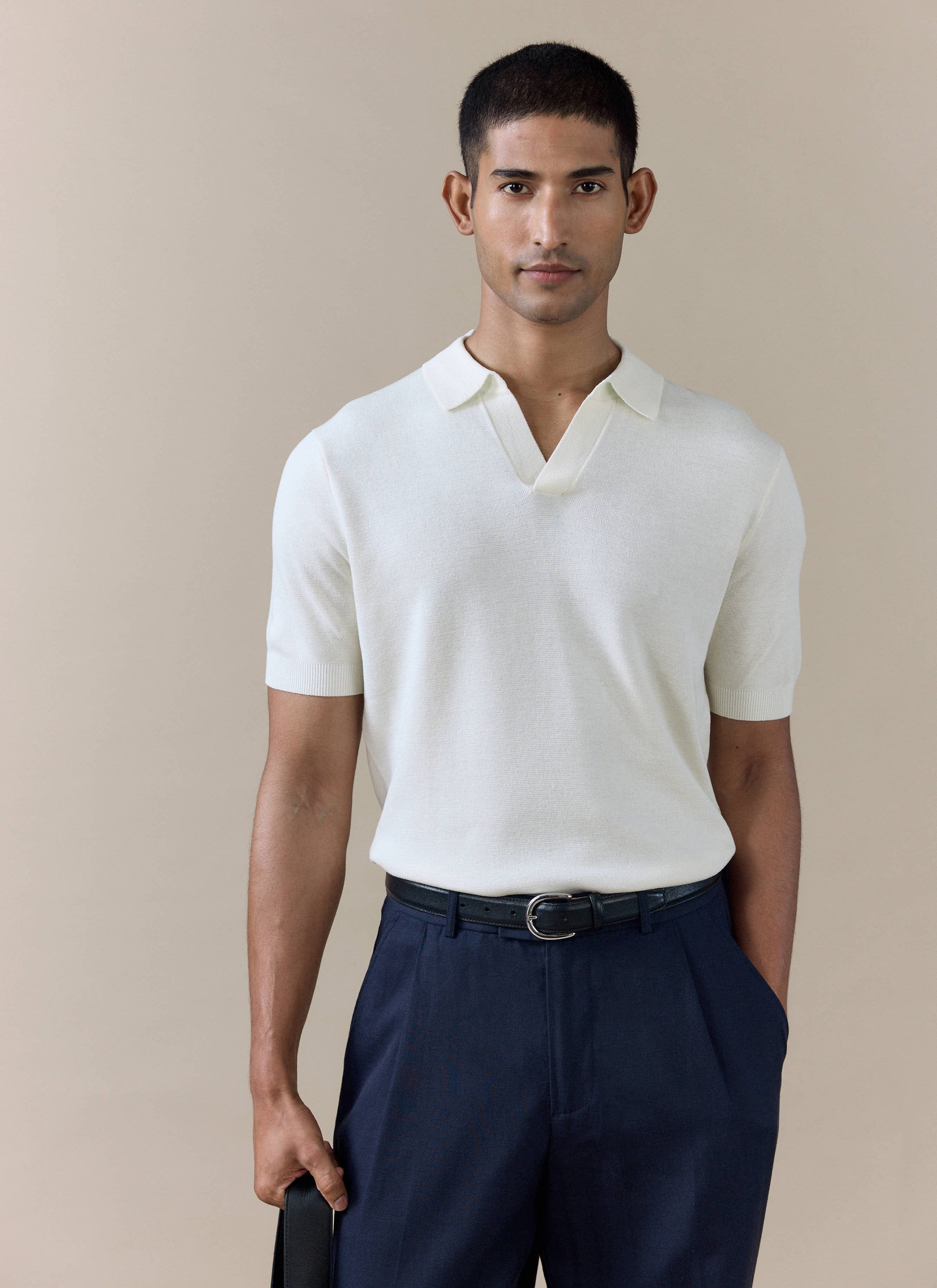 Percival Laurence knitted polo in cream linen blend, featuring an open Johnny collar and tailored fit on a male model.