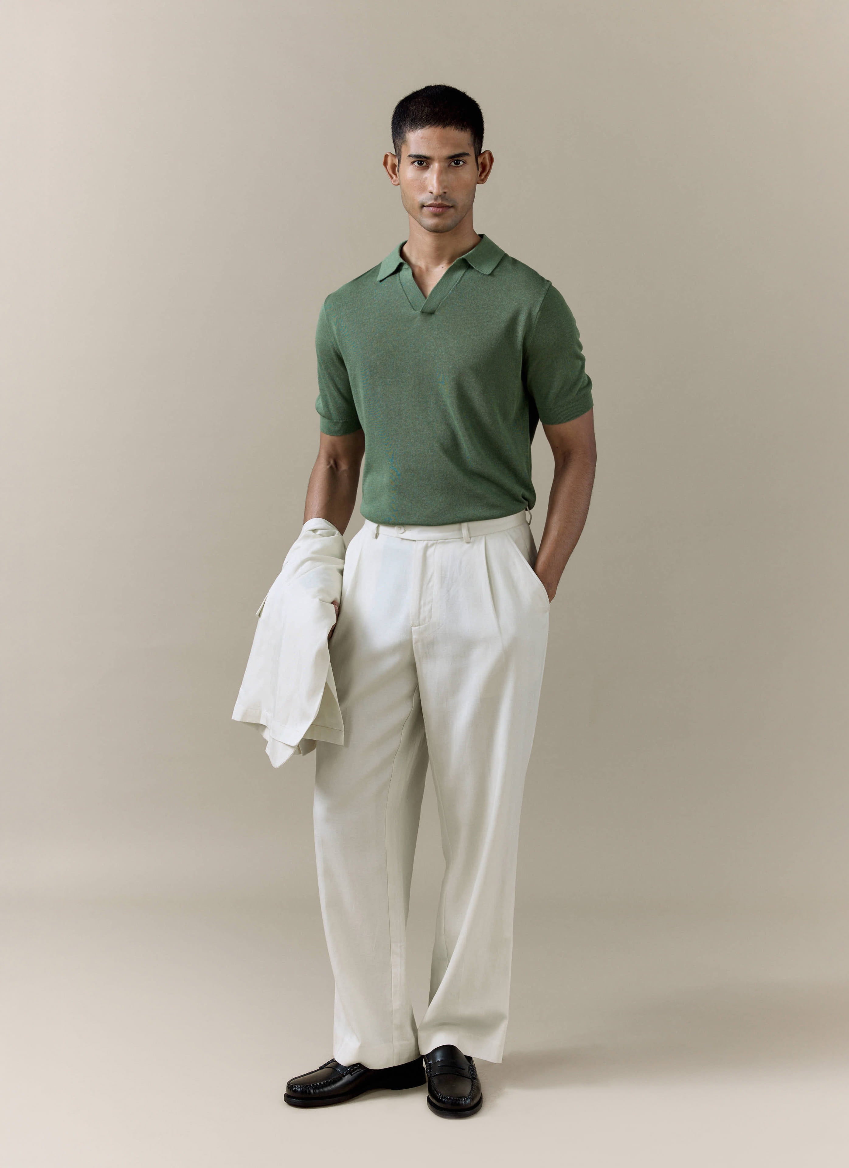 Percival Laurence Knitted Polo in forest green linen blend, styled with cream pleated trousers and a matching jacket.