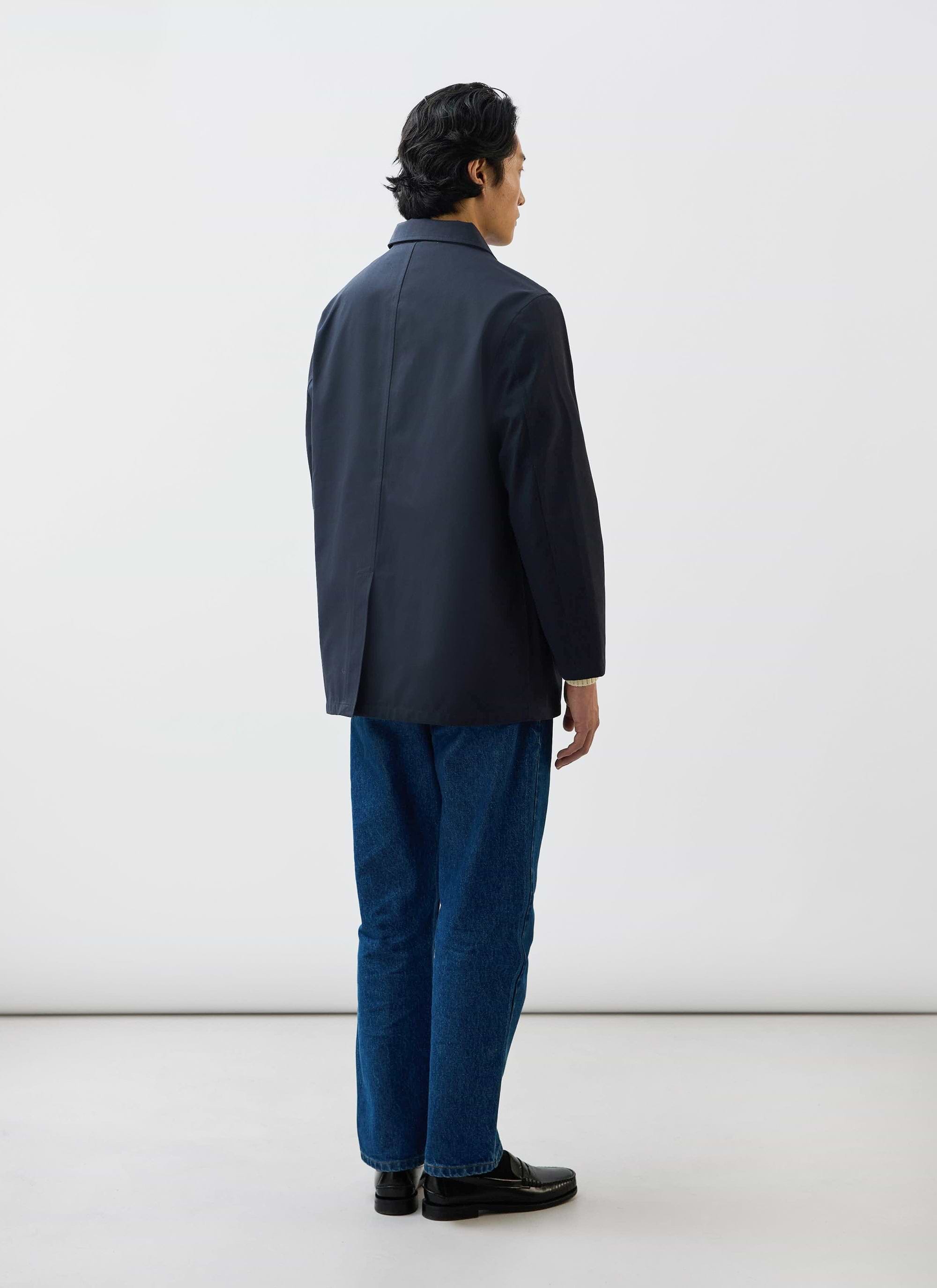 Rear view of a model wearing the Percival Sherlock Short Trench Coat in midnight navy waterproof technical fabric.