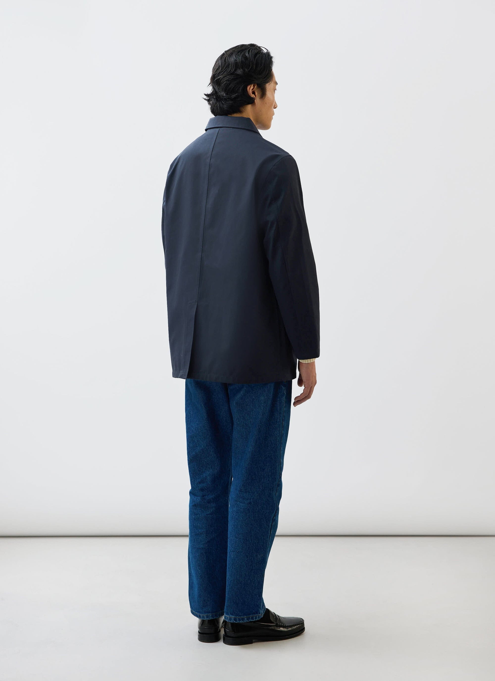 Rear view of a model wearing the Percival Sherlock Short Trench Coat in midnight navy waterproof technical fabric.