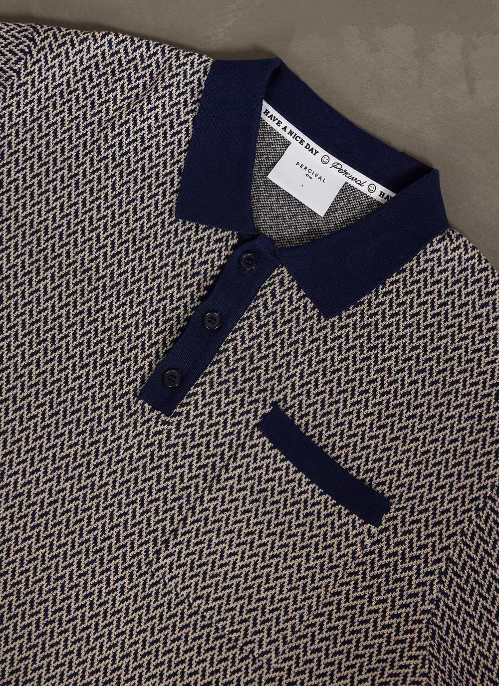 Close up of the Percival Casa Martini knitted polo in navy, showing the detailed geometric pattern, collar and placket.