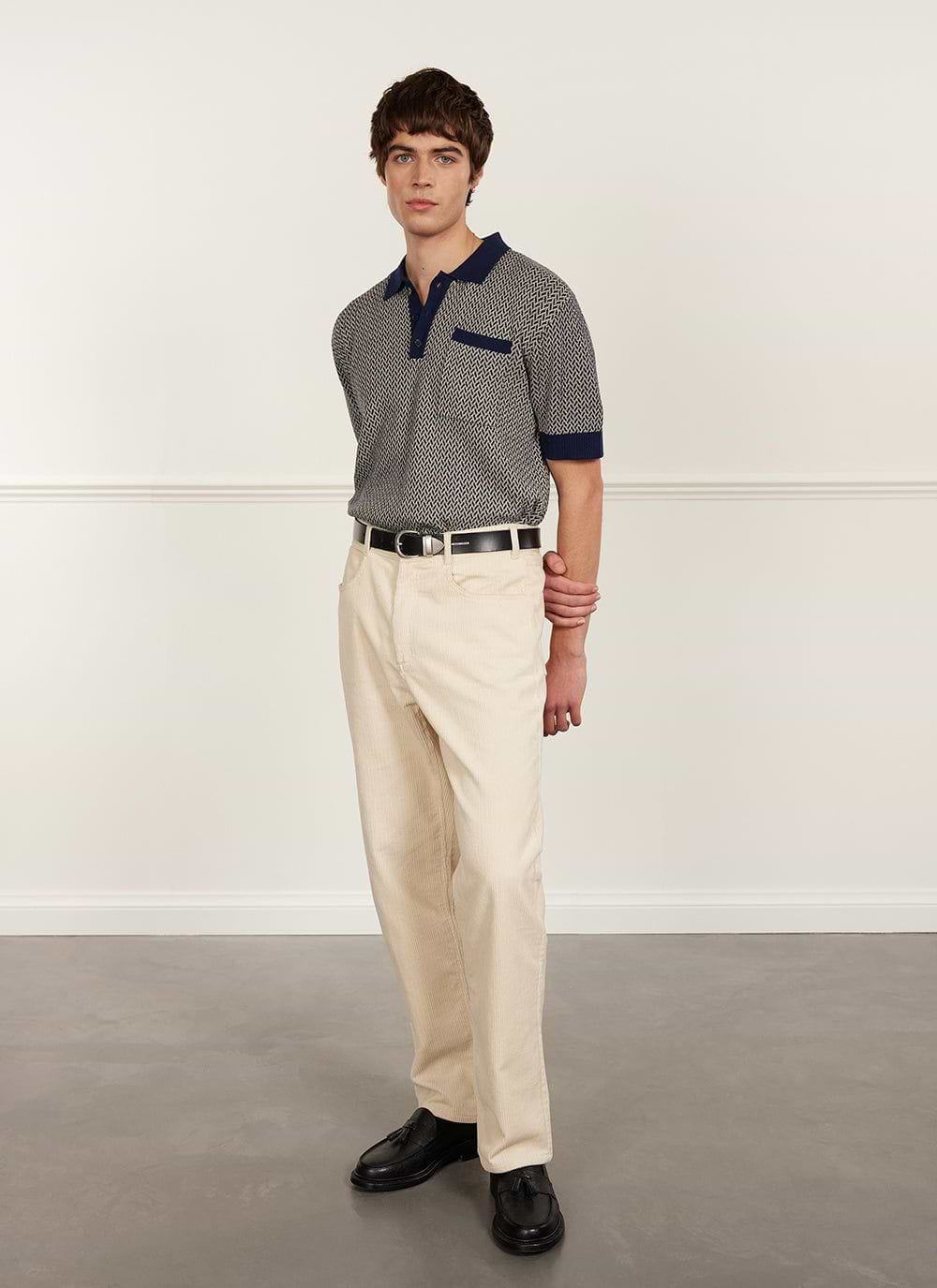 A model wears the Percival Casa Martini Knitted Polo in Navy with cream corduroy trousers and black loafers.