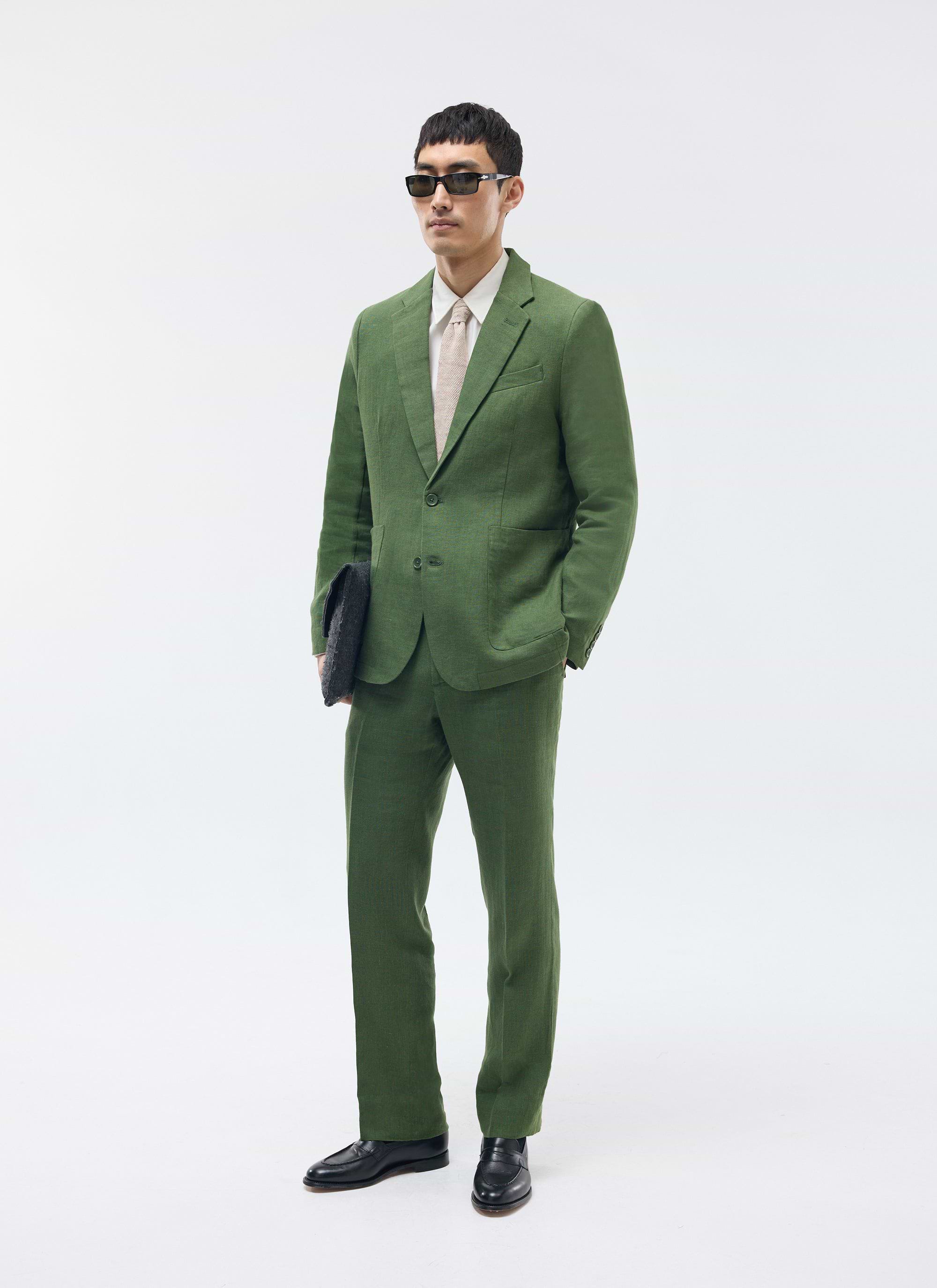 A model wears the Percival forest green linen blazer and matching trousers, styled with sunglasses and black loafers.