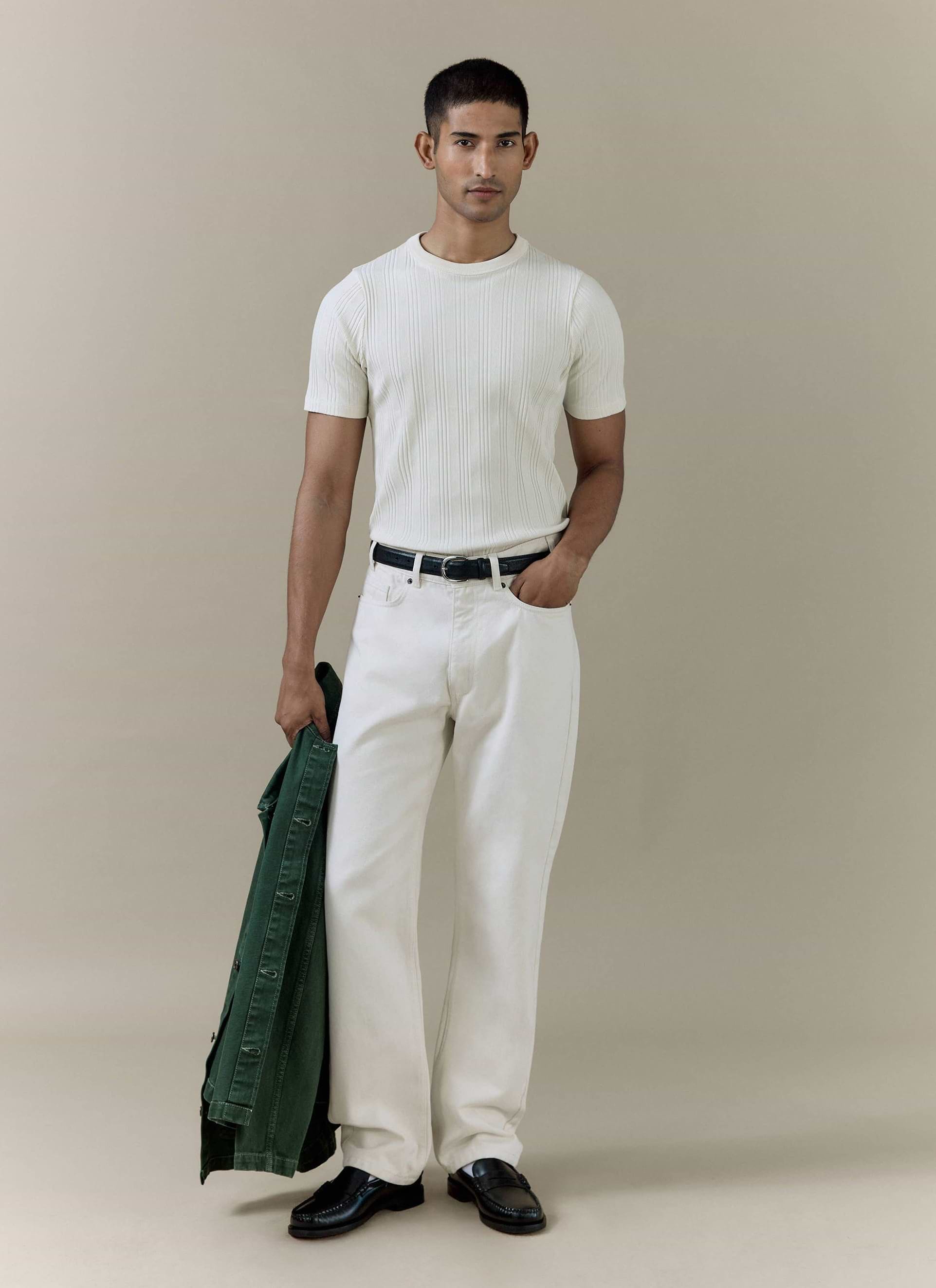 A model wears the cream Percival Leon Ribbed T-shirt and matching straight leg denim jeans with a green jacket.