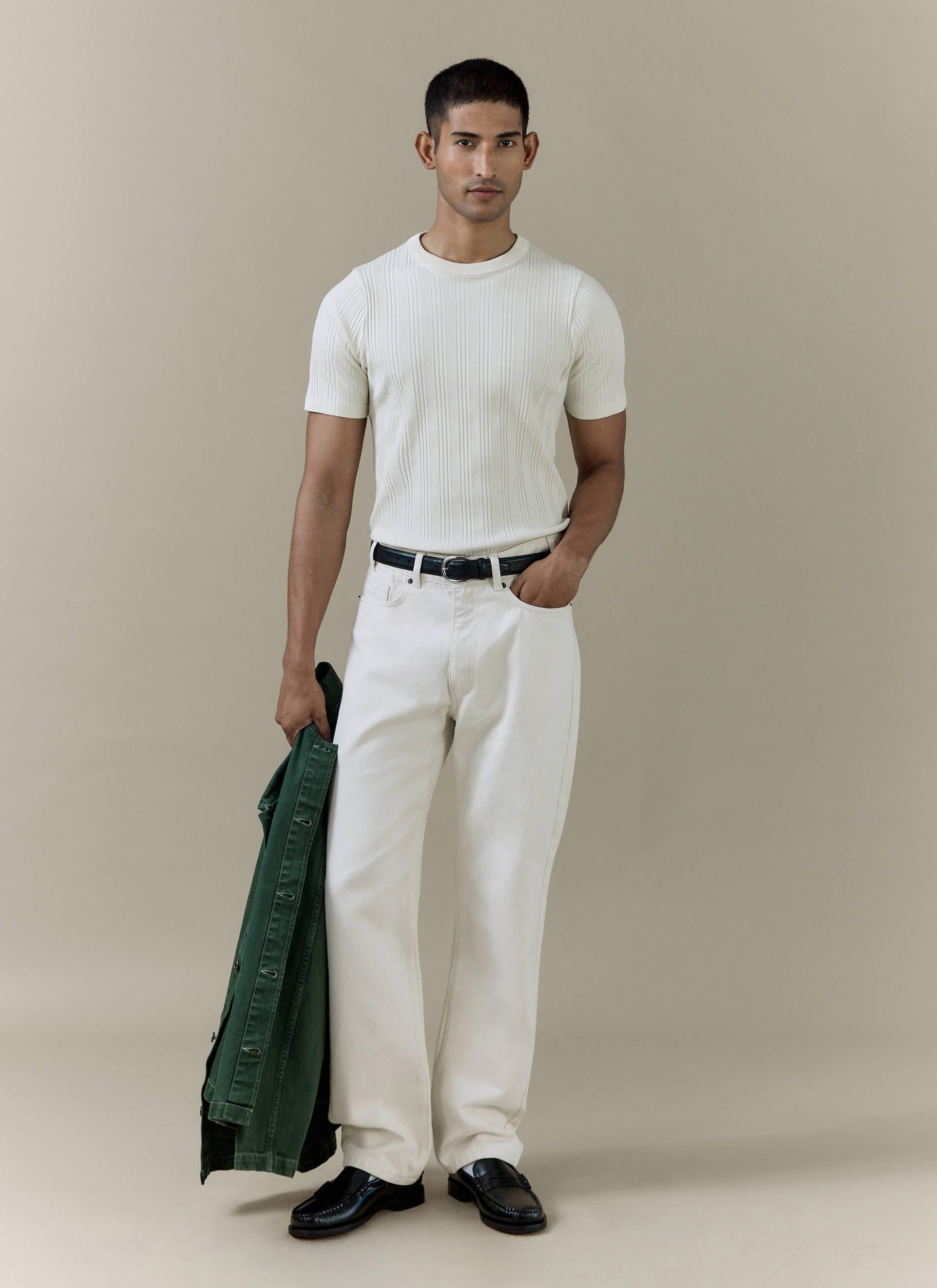 A model wears the cream Percival Leon Ribbed T-shirt and matching straight leg denim jeans with a green jacket.