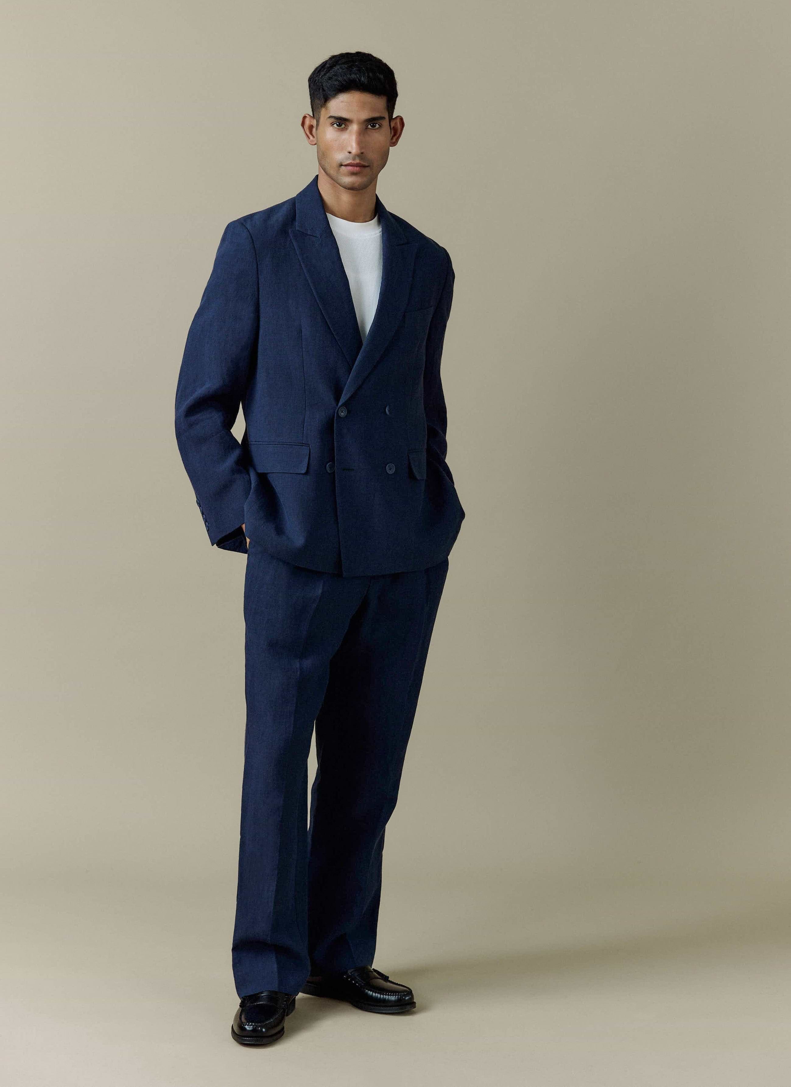 A full-length shot of a model wearing the Percival Clifton Boxy Double Breasted Blazer and matching trousers in navy linen.