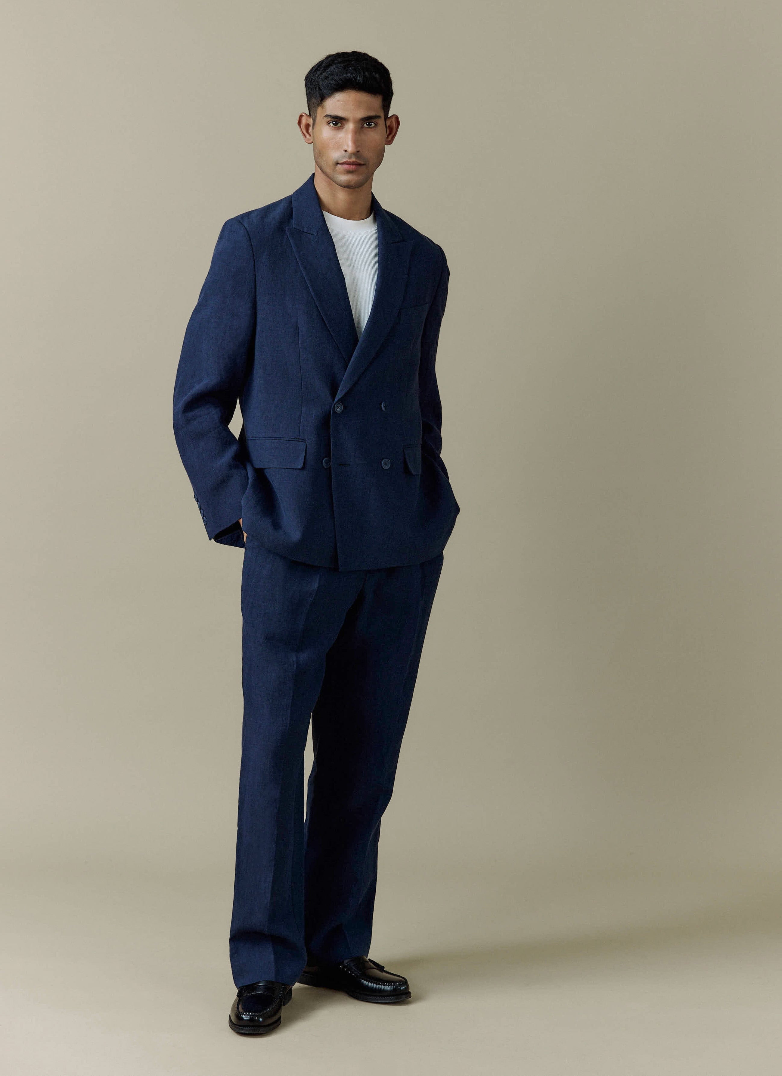 A full-length shot of a model wearing the Percival Clifton Boxy Double Breasted Blazer and matching trousers in navy linen.