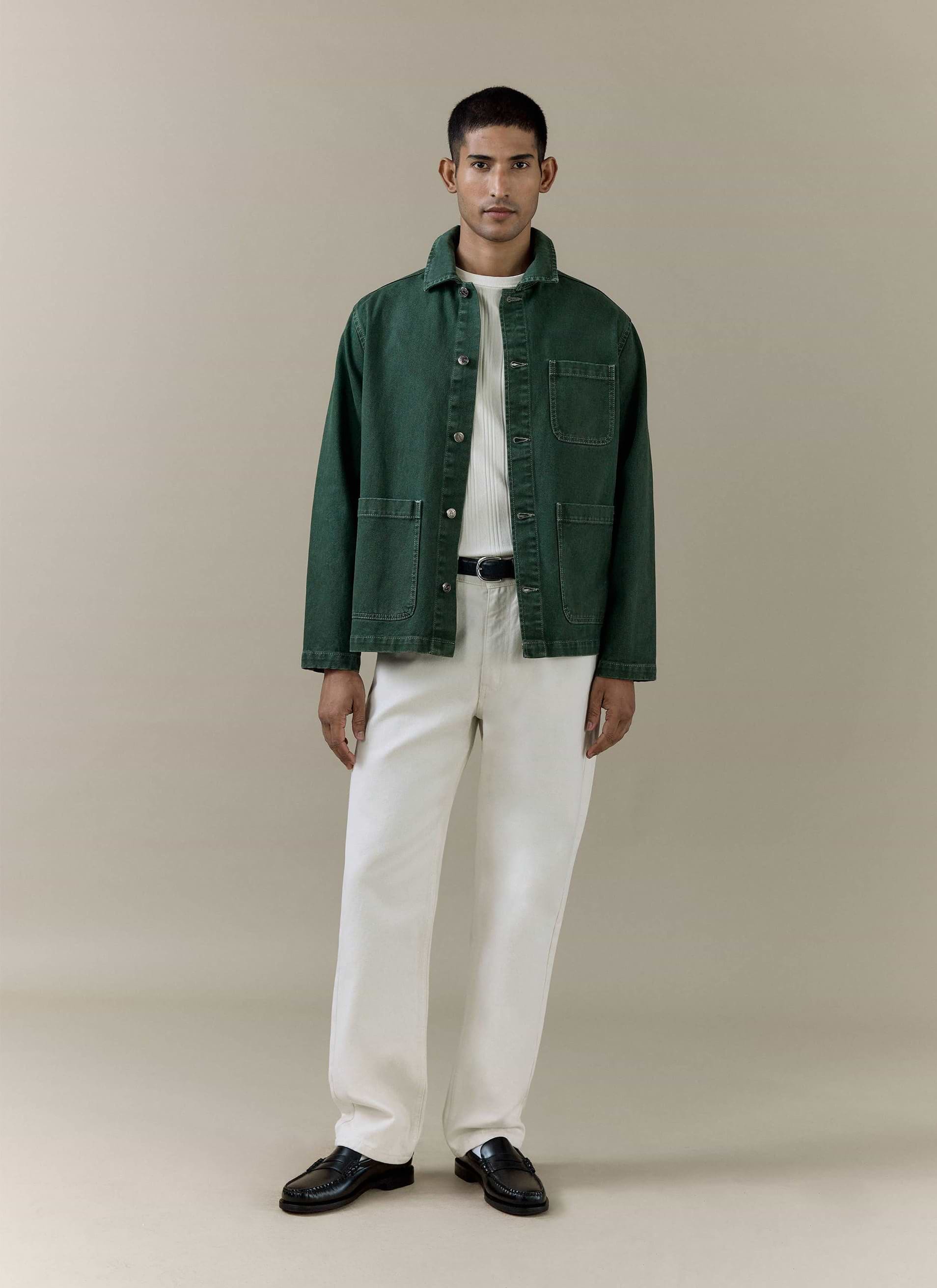 Percival Vintage Wash Oliver Chore Jacket in forest green cotton canvas, styled on a model with white trousers.